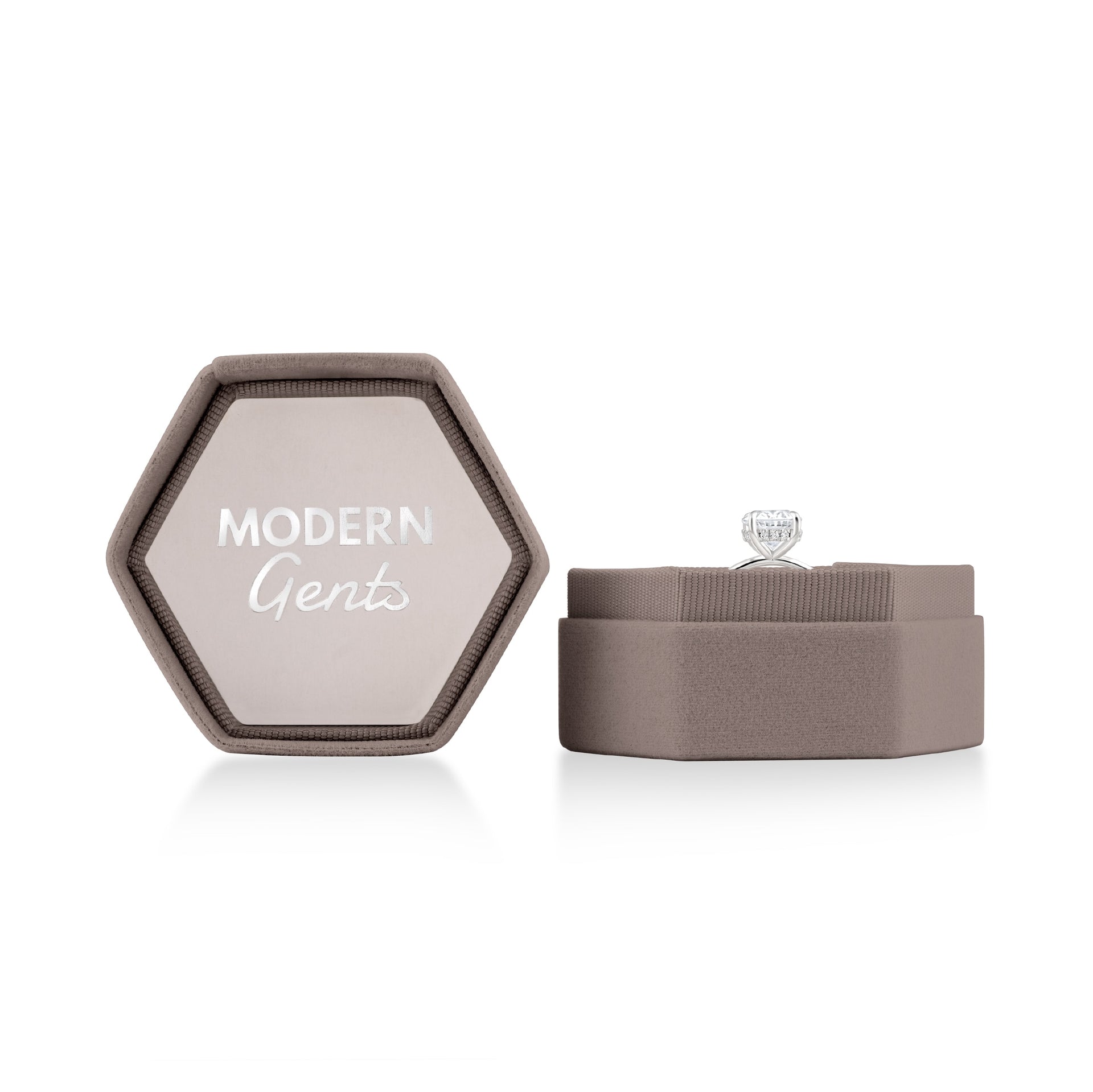 Open taupe velvet hexagon box with silver Modern Gents logo on the inside of the lid & a ring sitting in the bottom portion of the box on a white background 