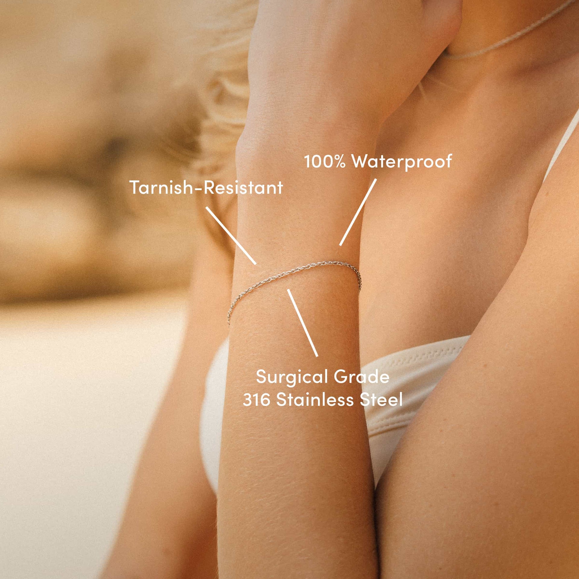 a silver stainless steel twisted detail cable chain bracelet worn by model with text overlayed "tarnish-resistant, 100% waterproof, surgical grade 316 stainless steel"