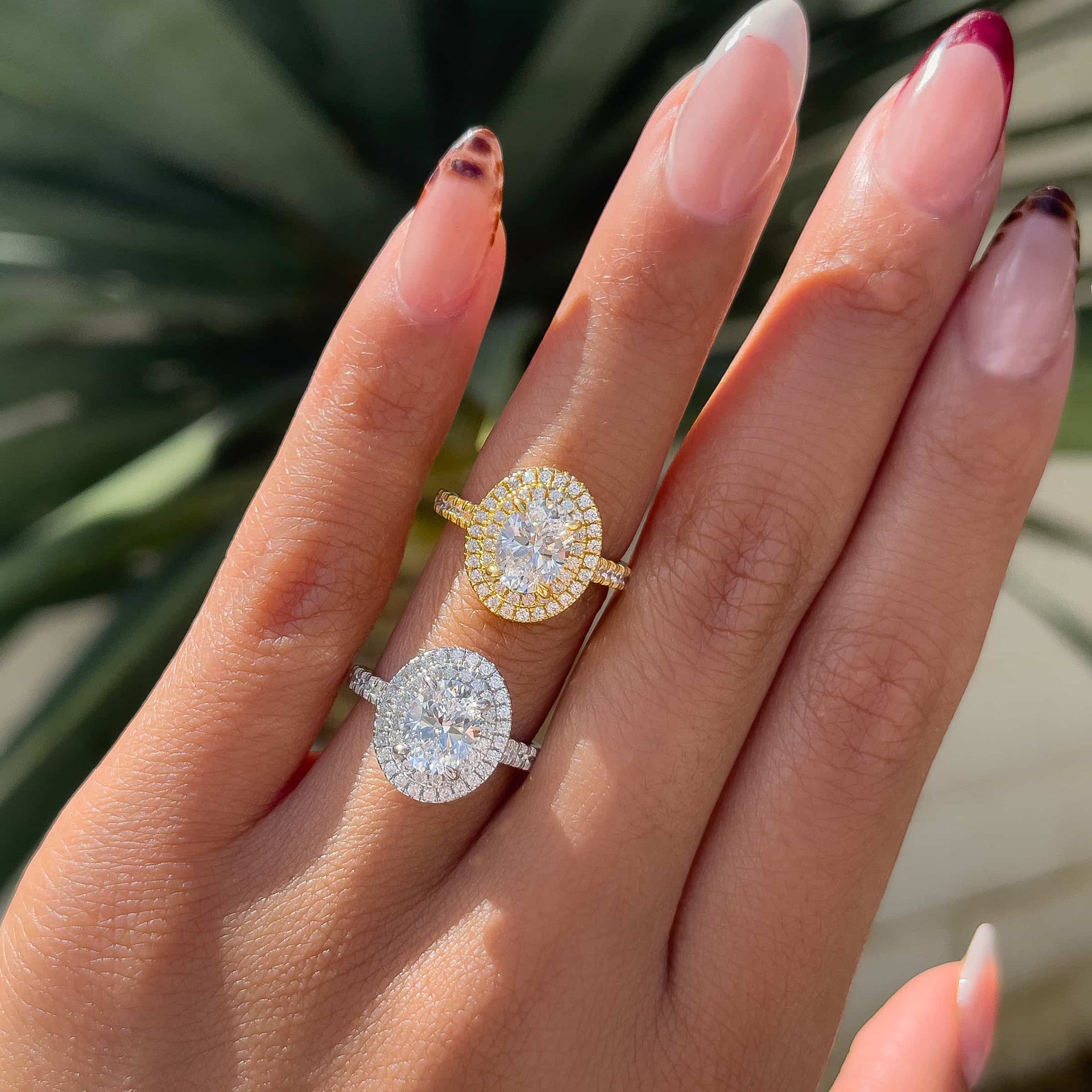 1.5 carat oval cut double halo half eternity engagement ring shown on a model in both silver and gold