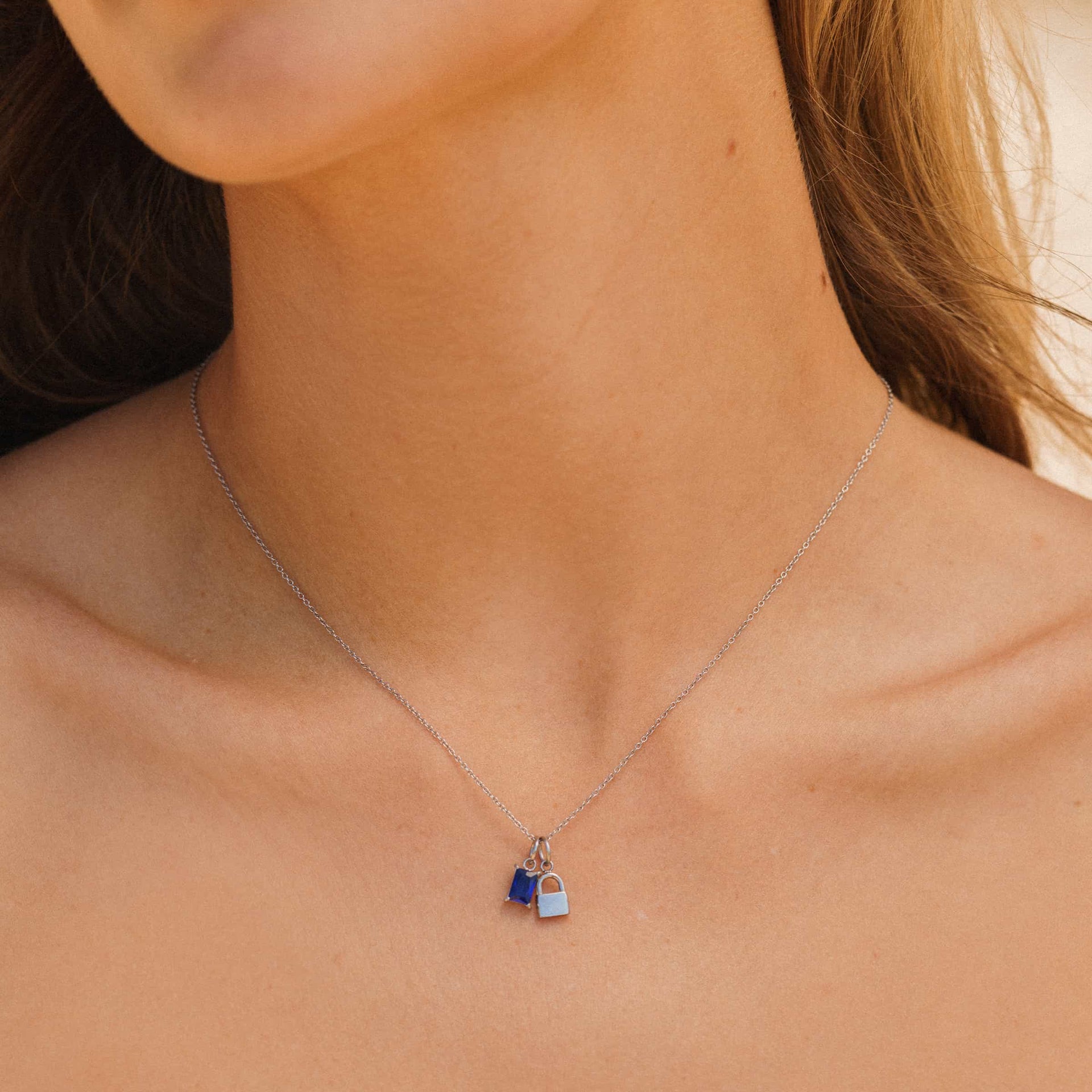 Silver Stainless Steel Lock Charm on simple cable chain necklace with a birthstone and lock charm, worn by a model