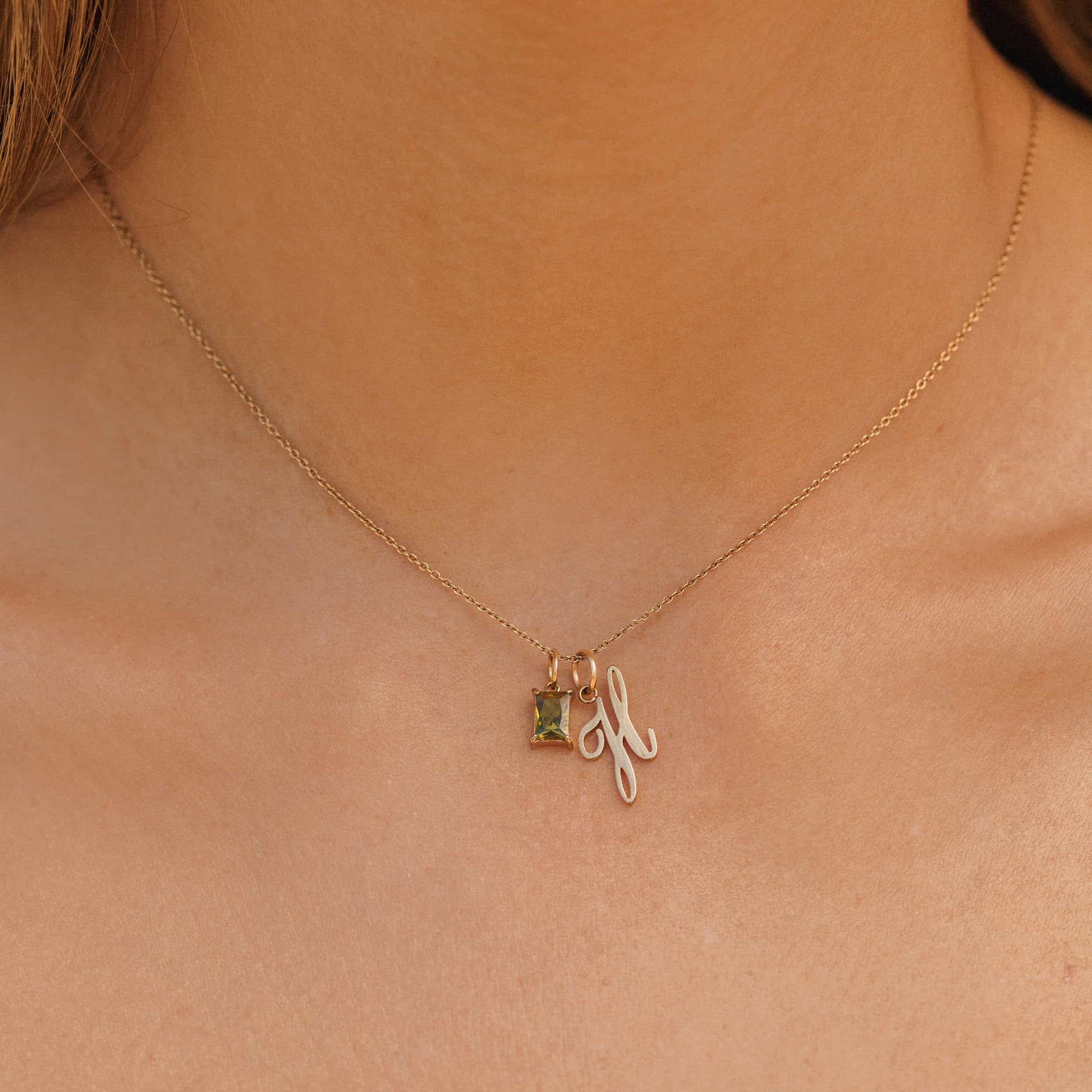 Dainty Gold Cable Chain Necklace worn with an August birthstone charm and cursive letter "H" pendant