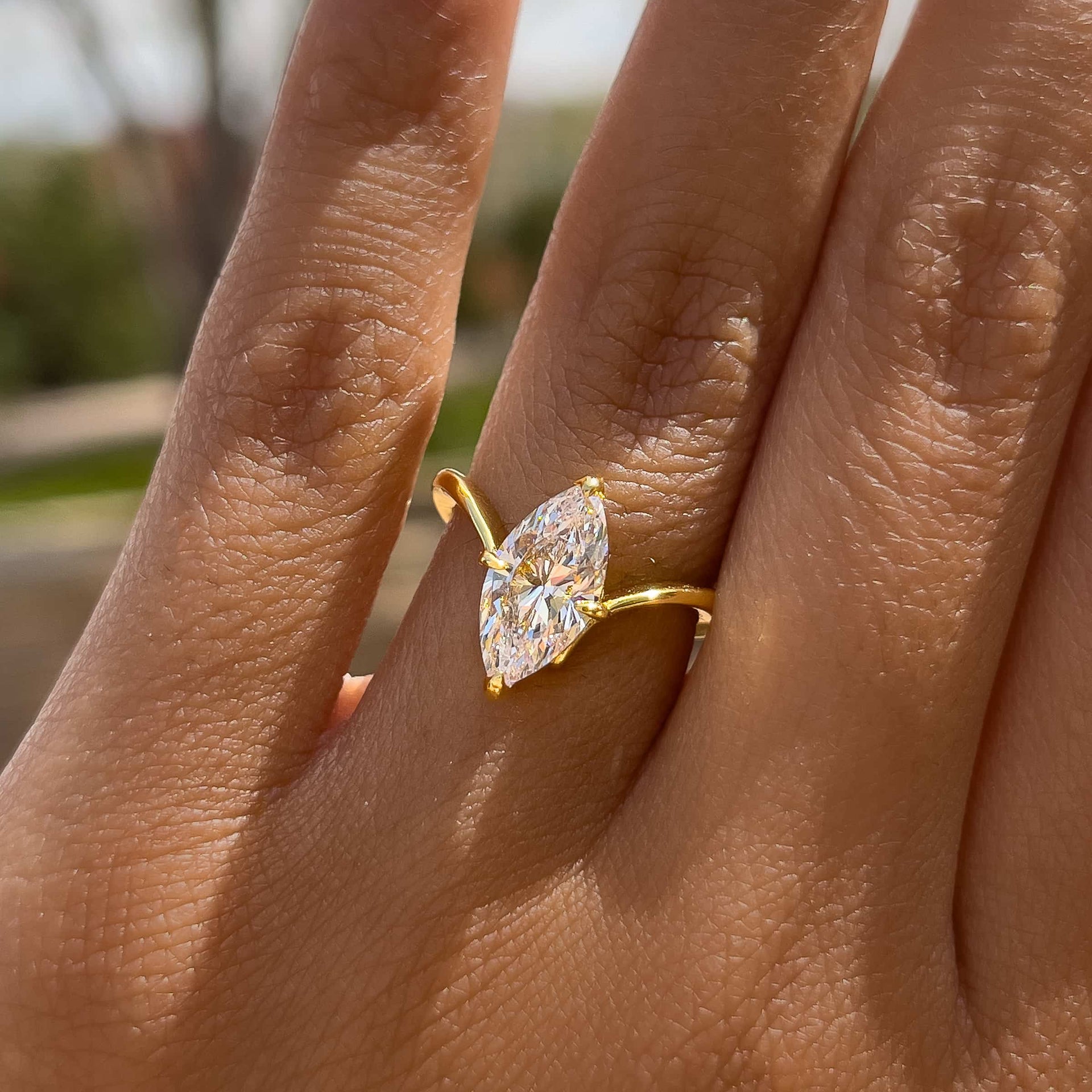 gold 2 carat marquise solitaire chevron engagement ring on model 
