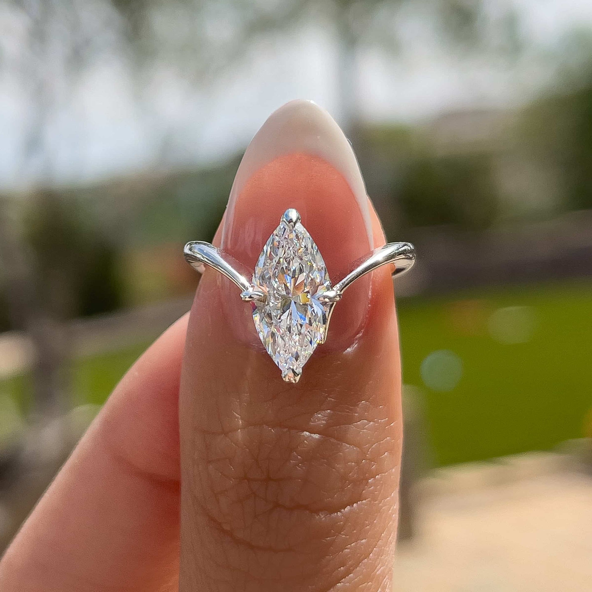 silver 2 carat marquise solitaire chevron engagement ring on model with french tip nails