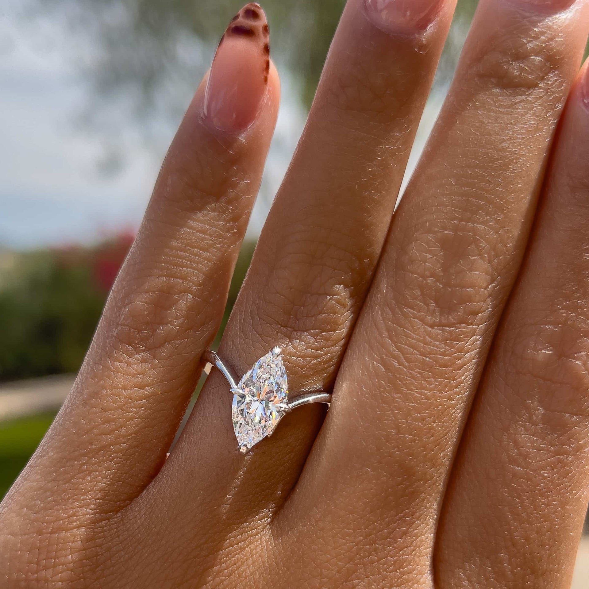 silver 2 carat marquise solitaire chevron engagement ring worn by model with unique nails