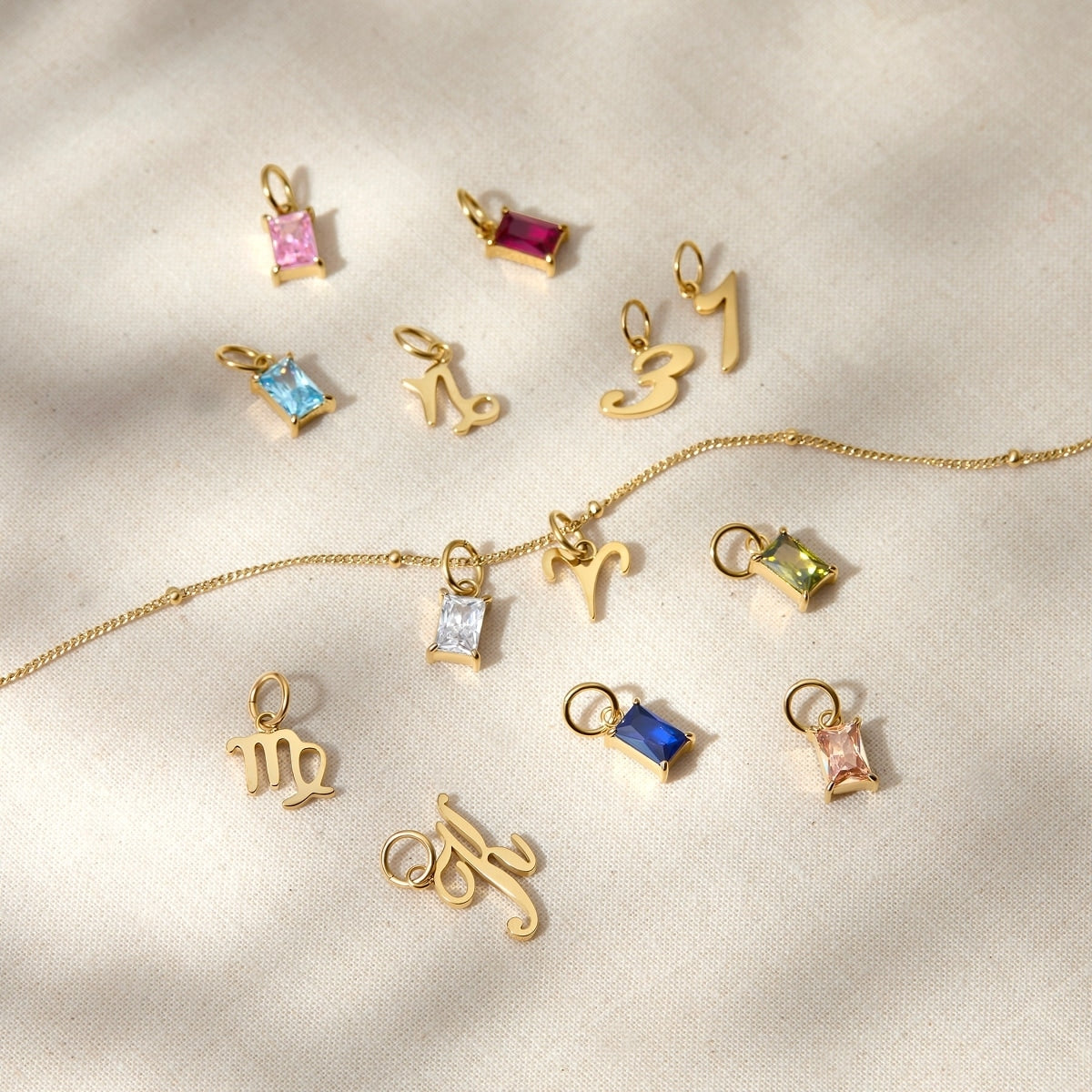a variety of dainty charms posed across a tan surface 