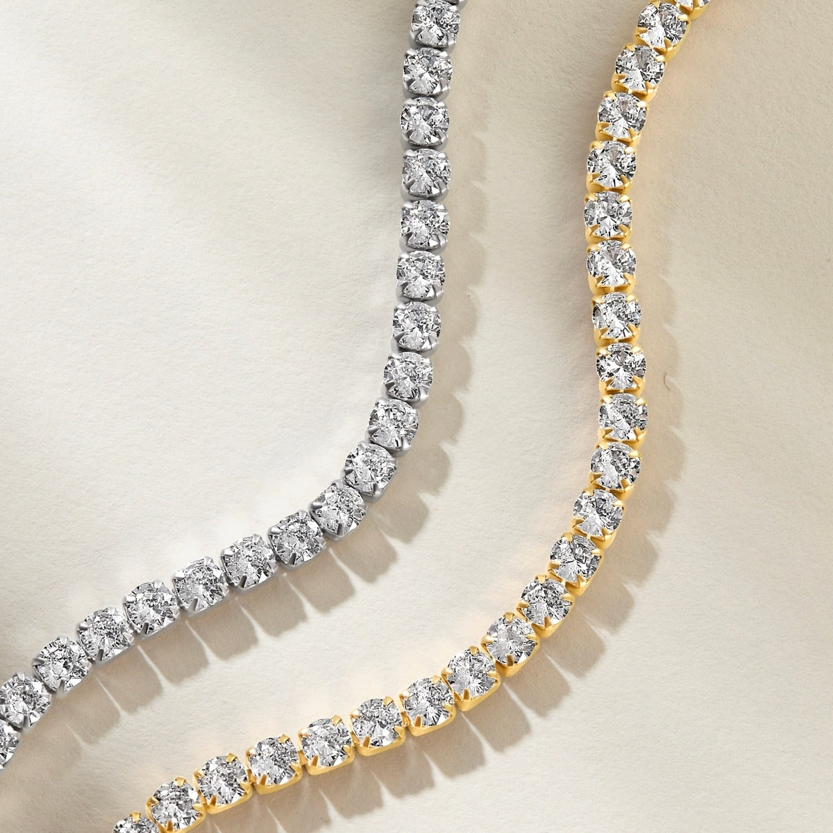 surgical grade 316 stainless steel tennis bracelets shown close up in both silver and gold variants on an off white background