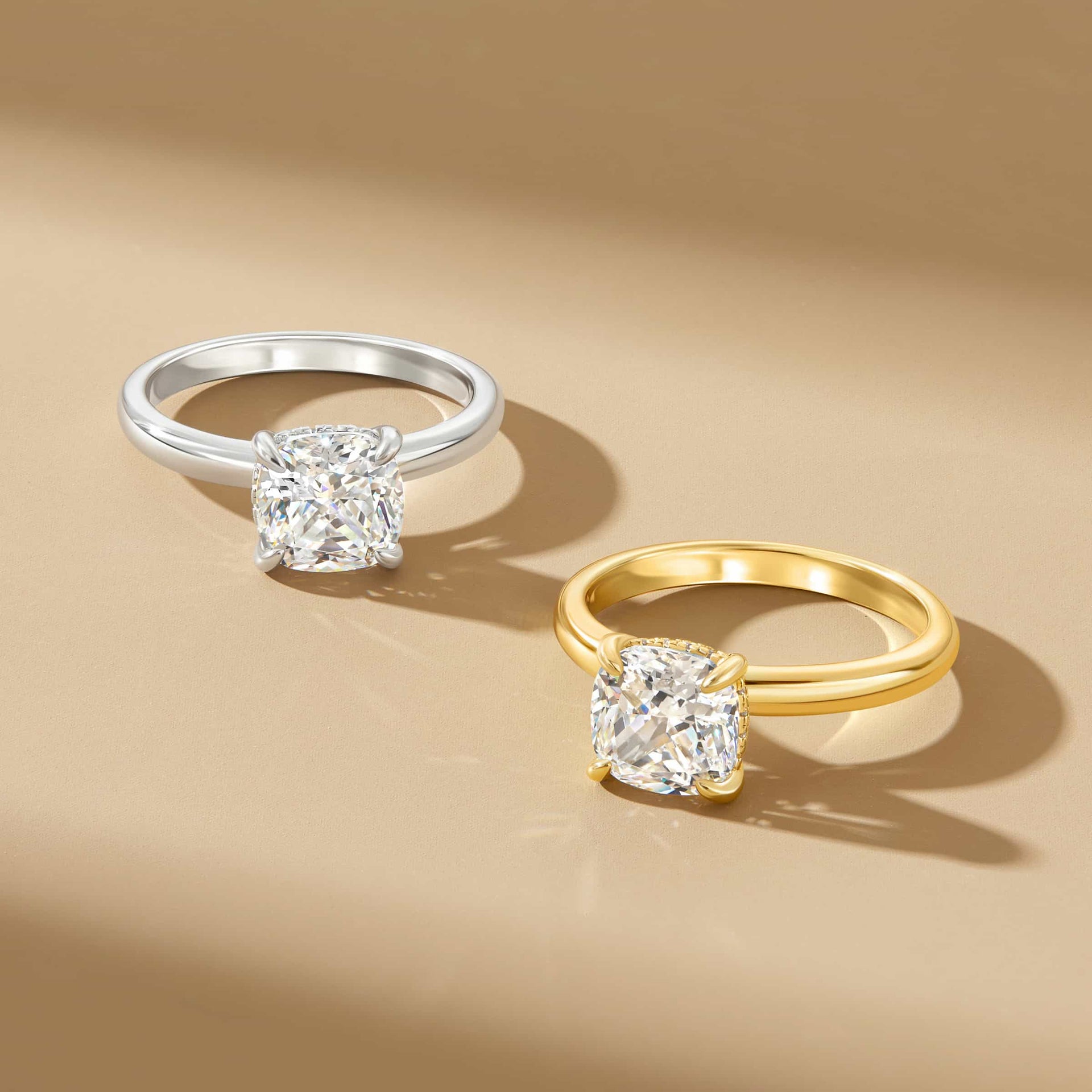 stunning gold and silver solitaire cushion cut engagement rings on tan background