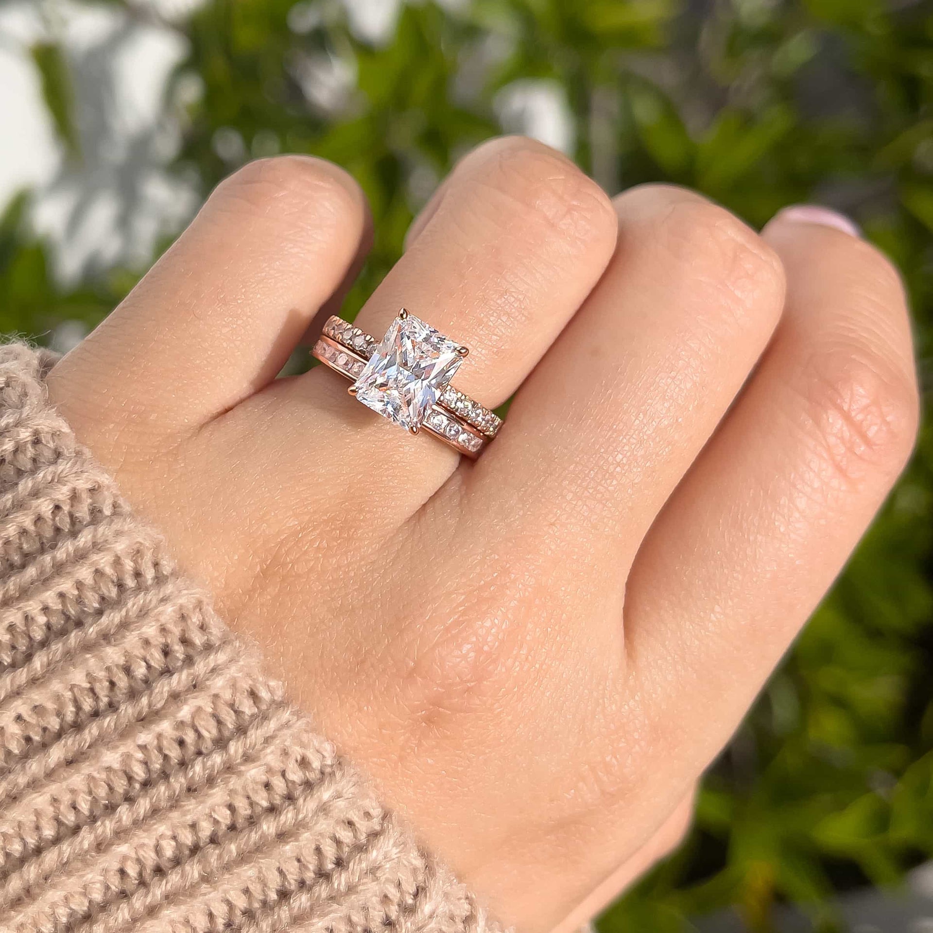 3 carat engagement ring shown in rose gold paired with a stunning rose gold wedding band shown on model wearing a tan sweater