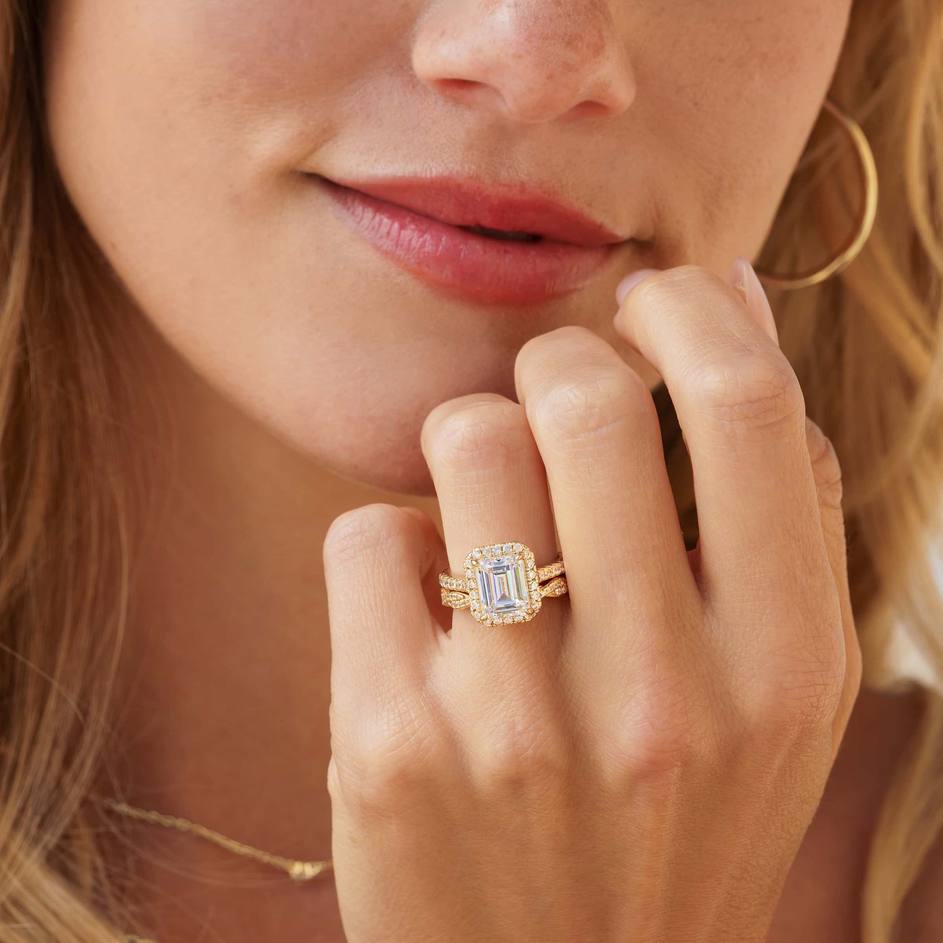 3 carat emerald cut engagement ring shown in gold paired with a vintage stunning gold wedding band shown on model