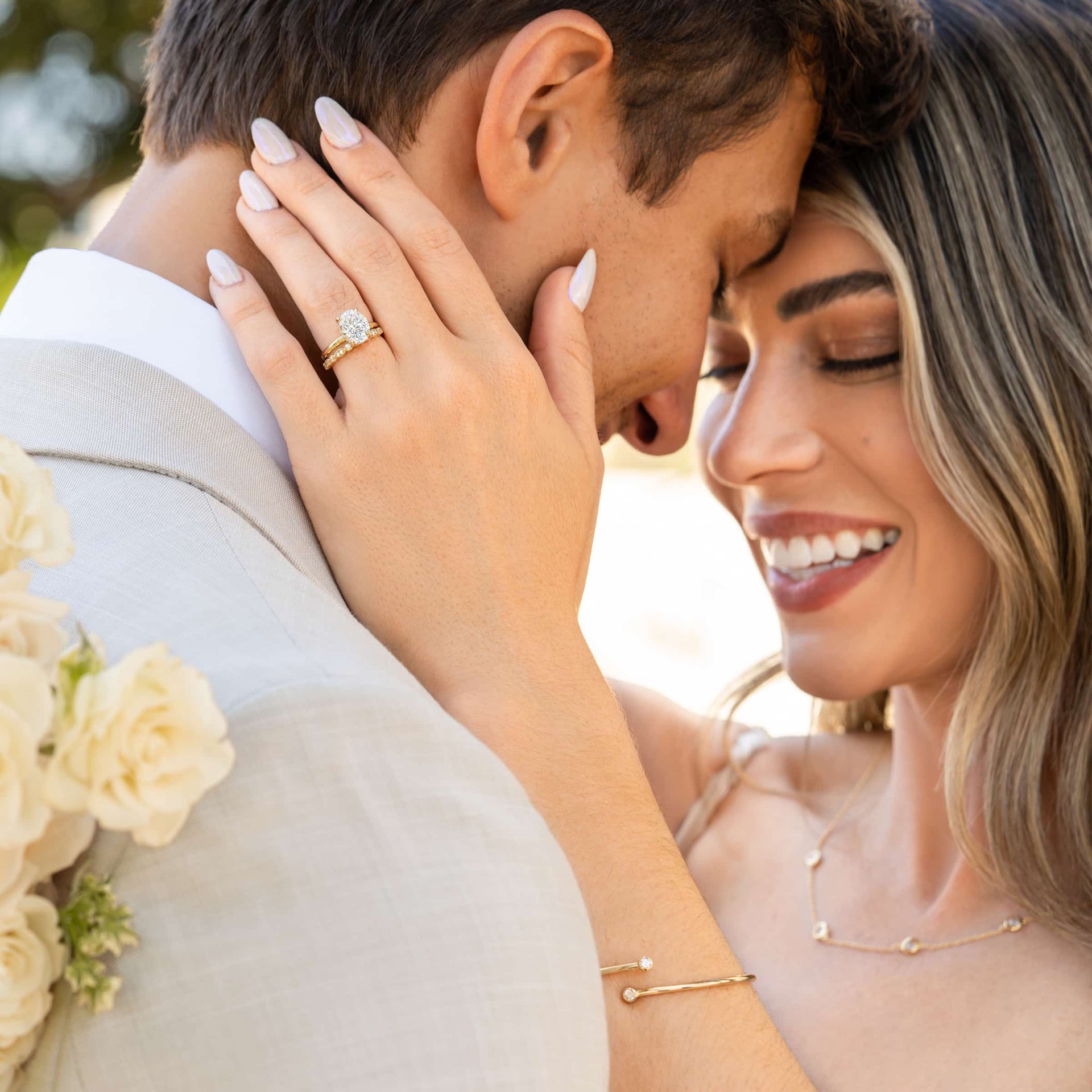 couple hugging wearing gold oval cut engagement ring