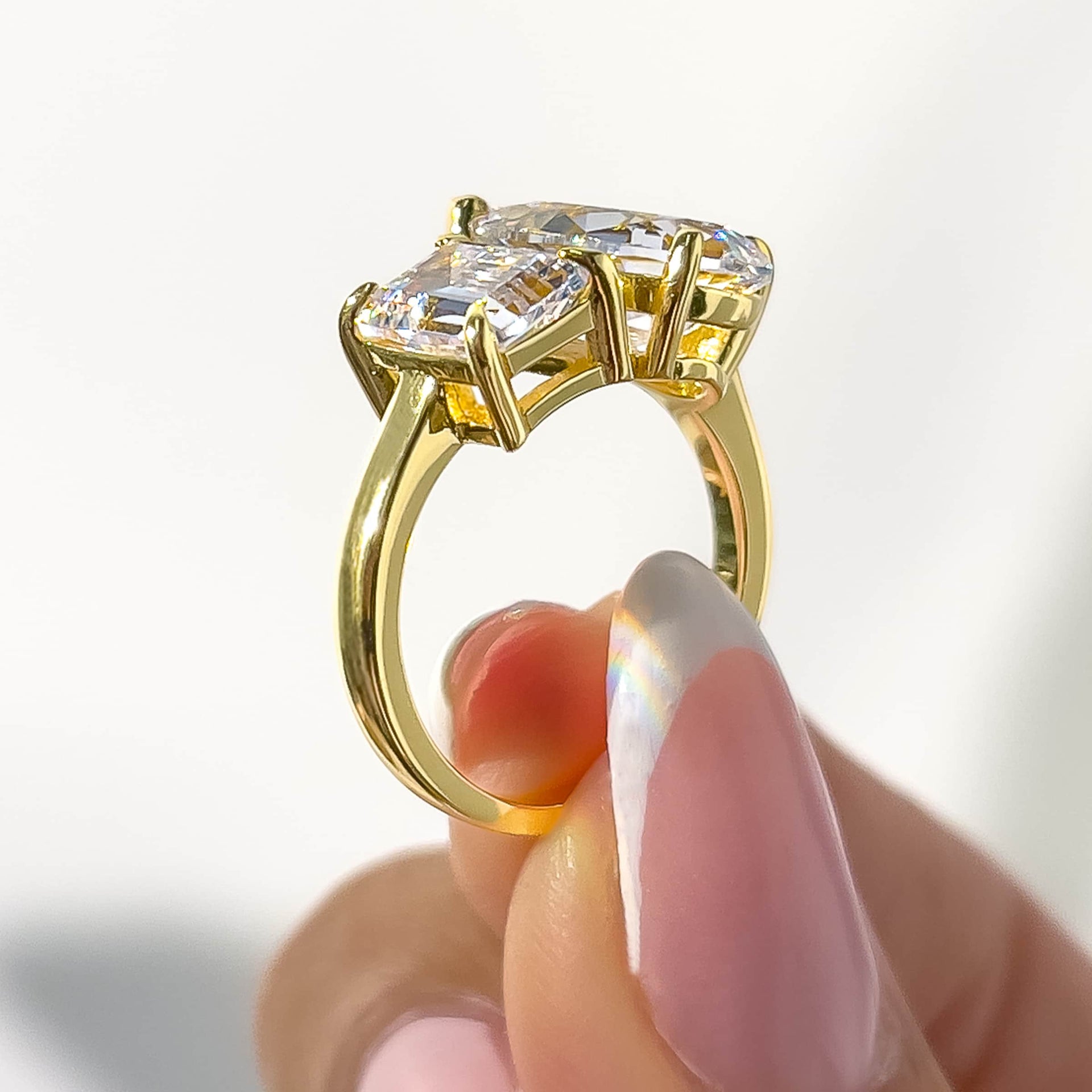 side view of gold emerald and pear cut toi et moi engagement ring