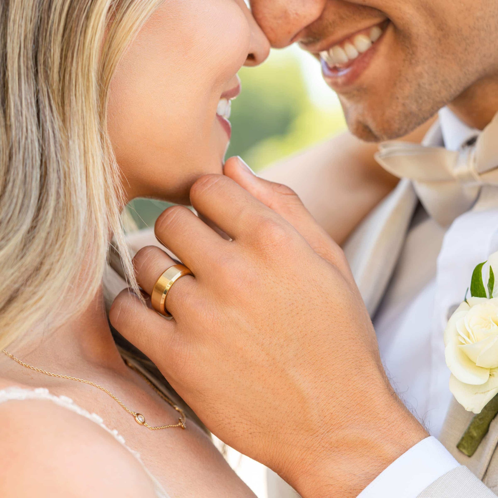 man wearing gold wedding band holding bride's chin