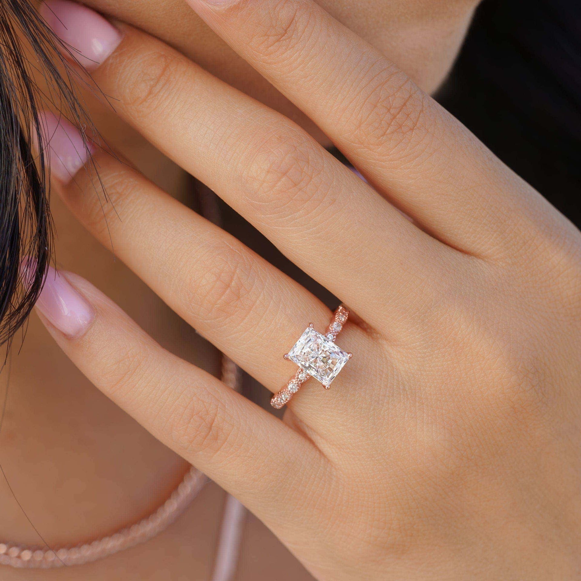 woman wearing rose gold radiant cut engagement ring