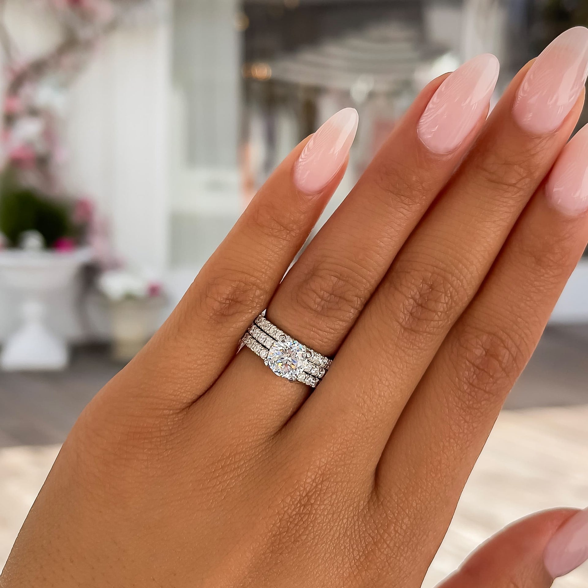 silver round cut wedding ring stack on female model with light pink nails