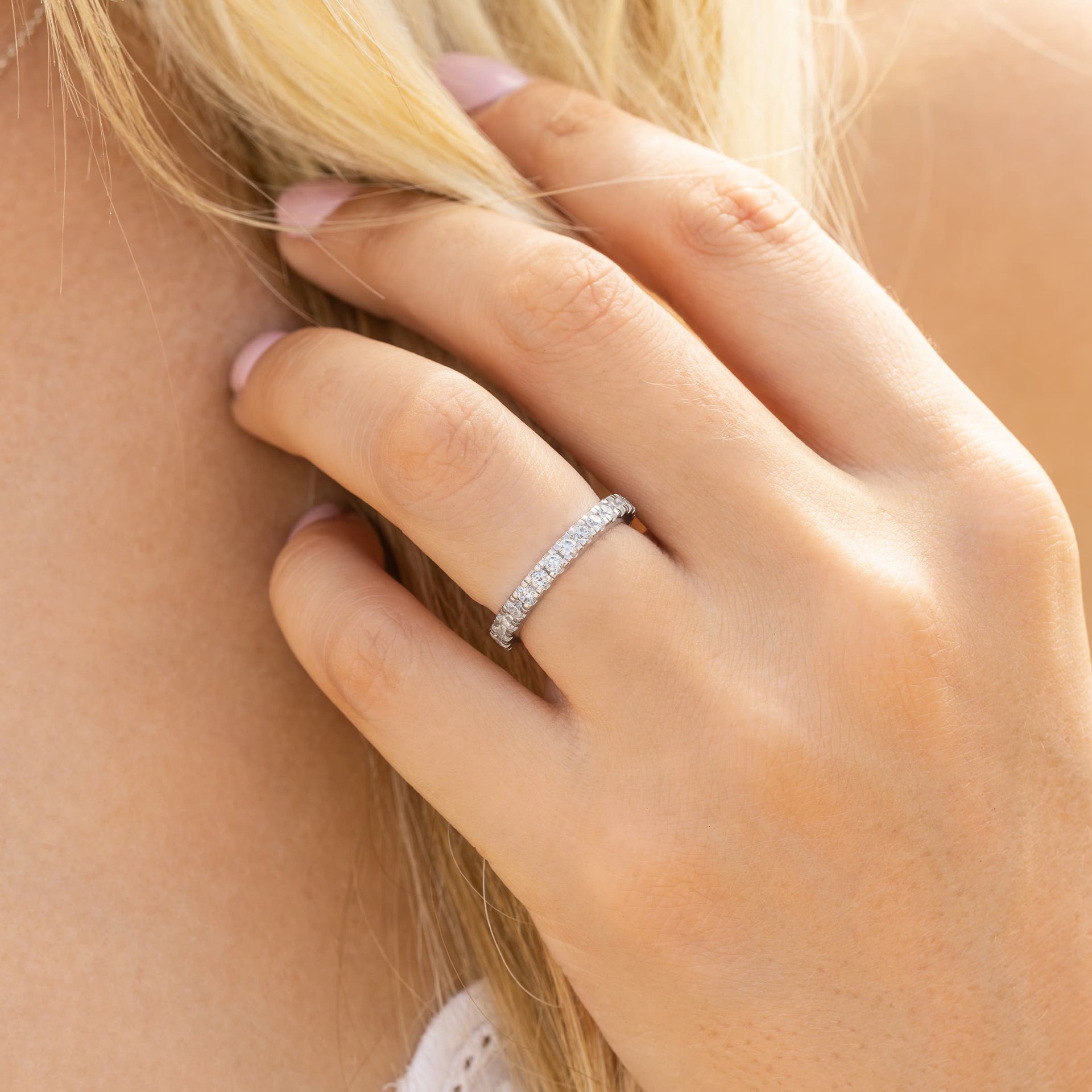 woman wearing silver eternity wedding band on hand