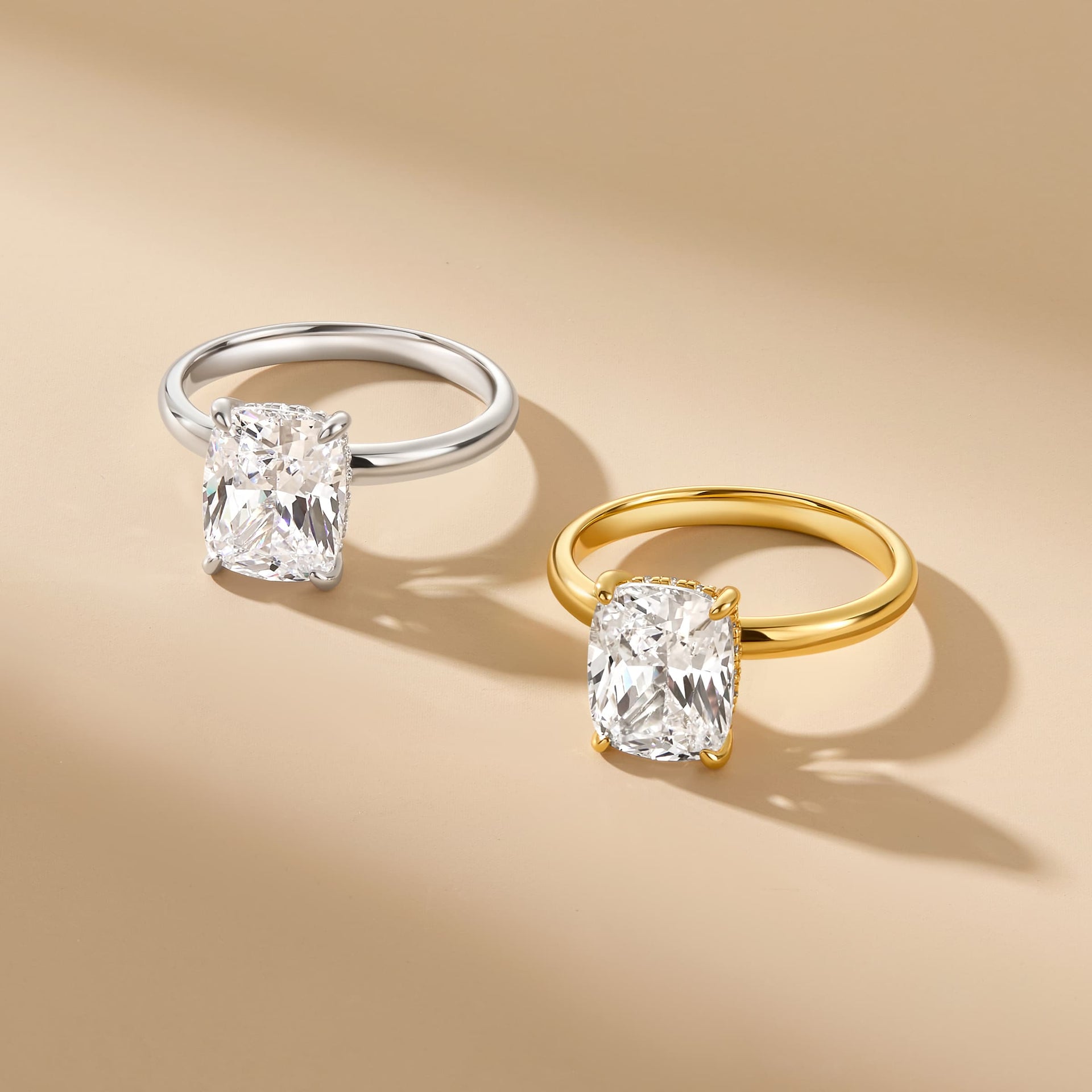 classic 4 carat elongated cushion cut solitaire engagement ring with hidden halo shown in silver and gold on neutral background