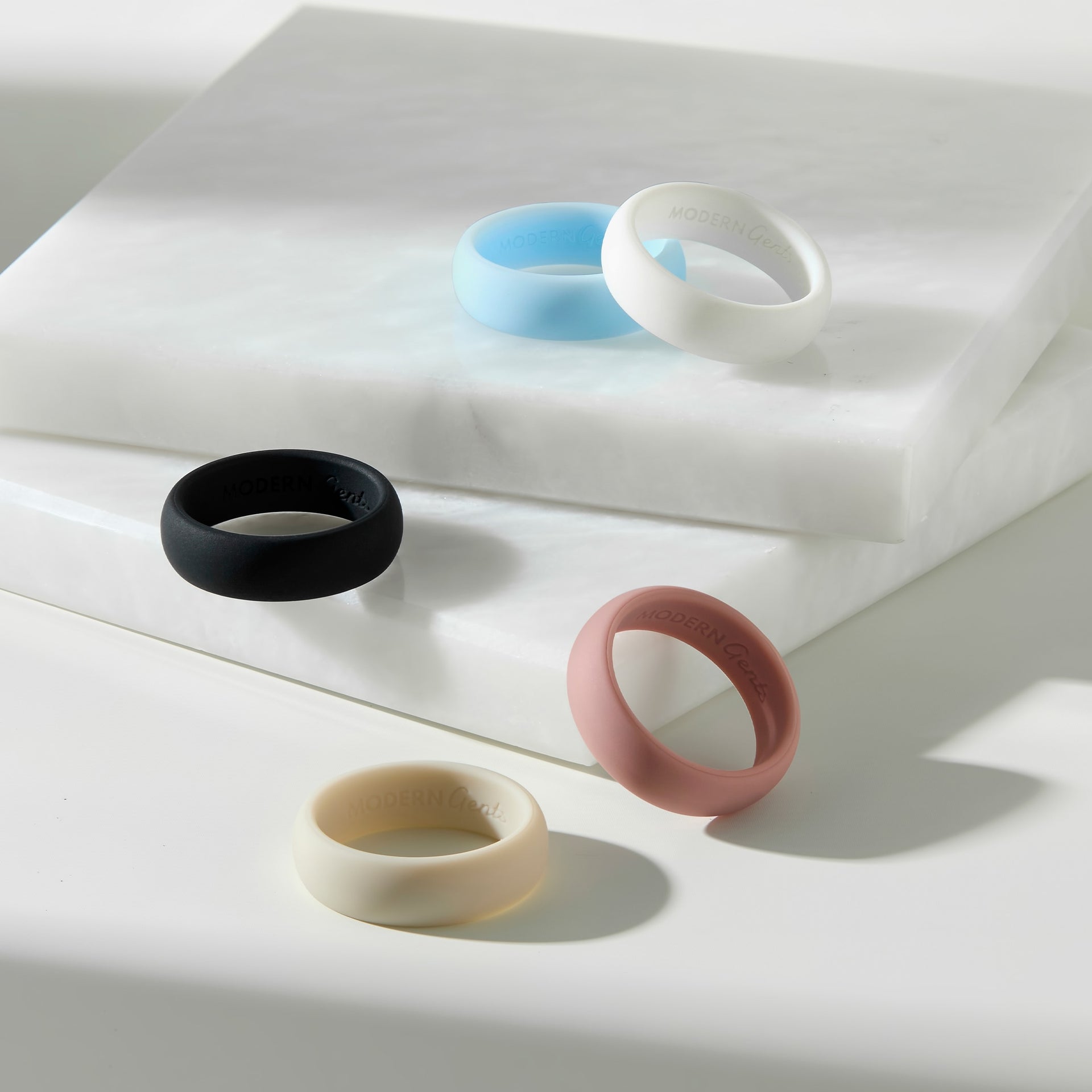 a slim and sleek silicone alternative band shown in colors: sky, white, black, dune, and pink sand on a white background