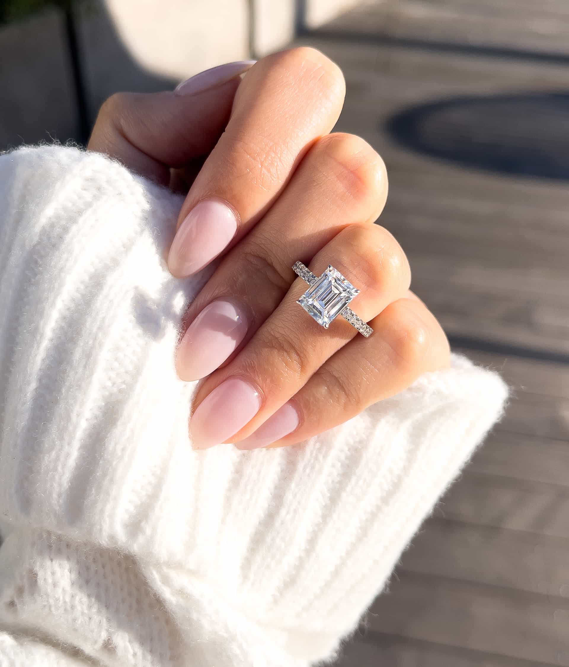 gorgeous silver emerald cut with white sweater and pink nails