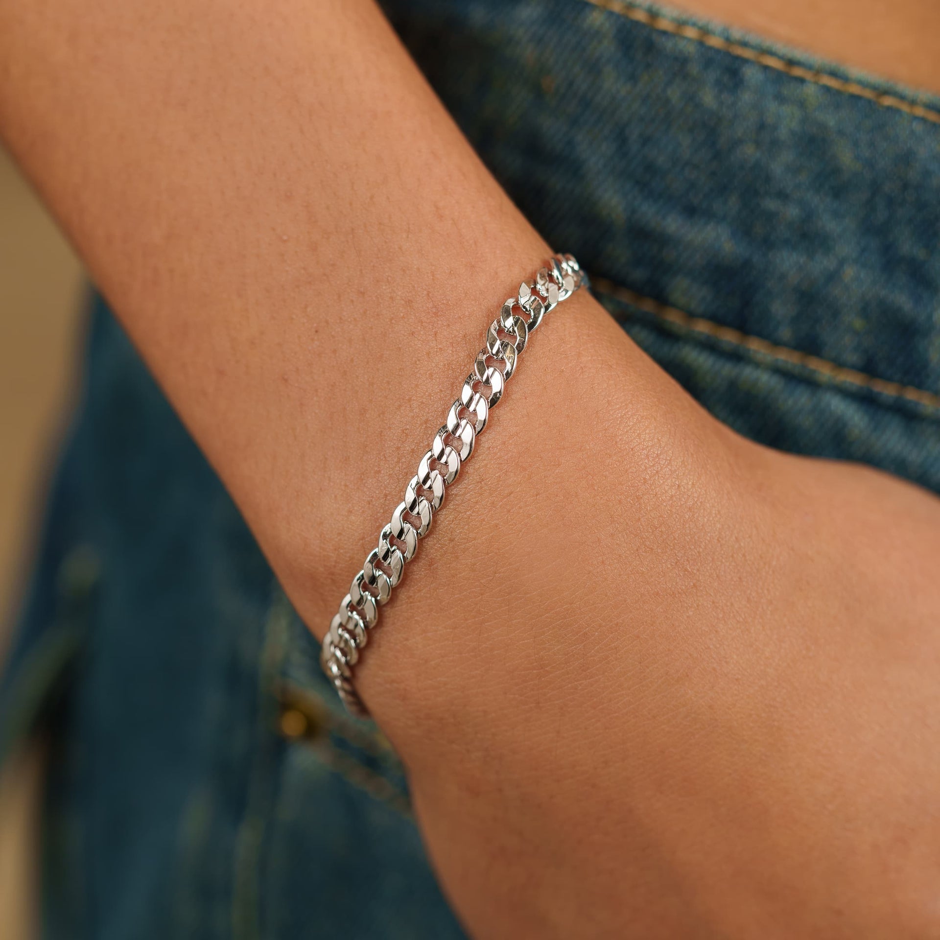 sleek silver cuban link everyday chain bracelet on model wearing dark denim