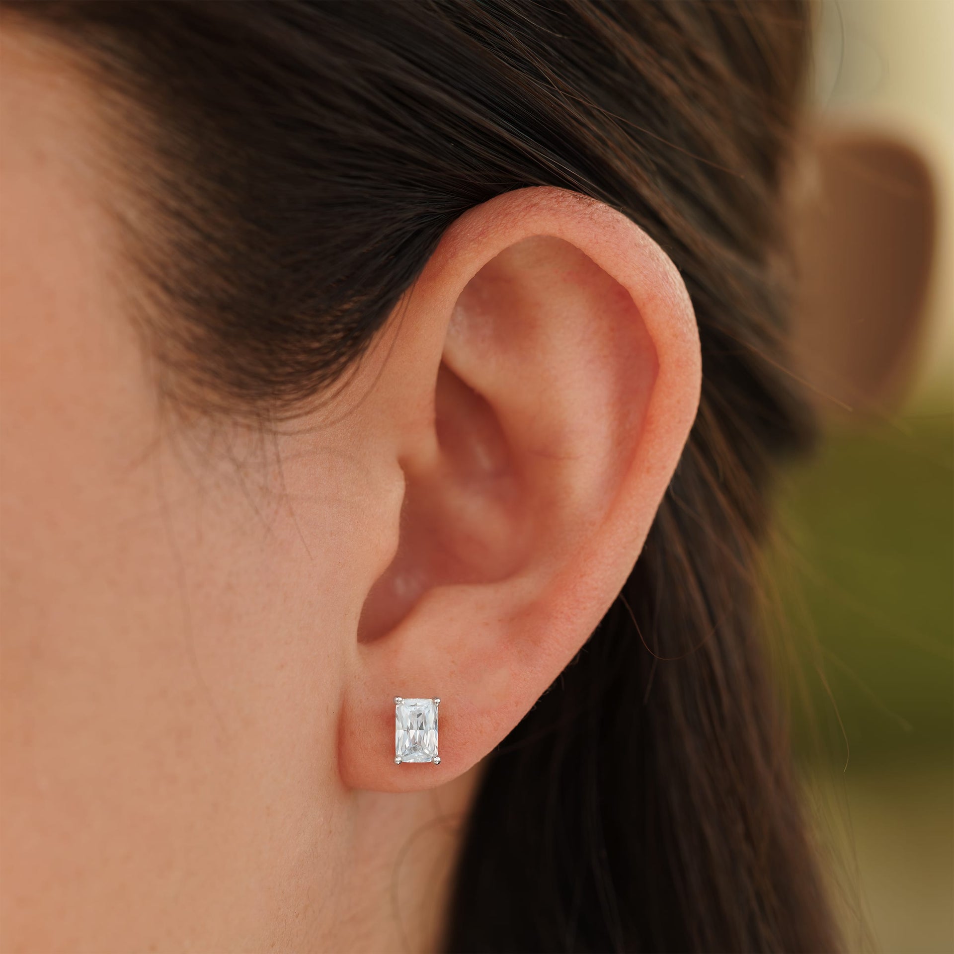 small silver radiant cut stud earrings on female model