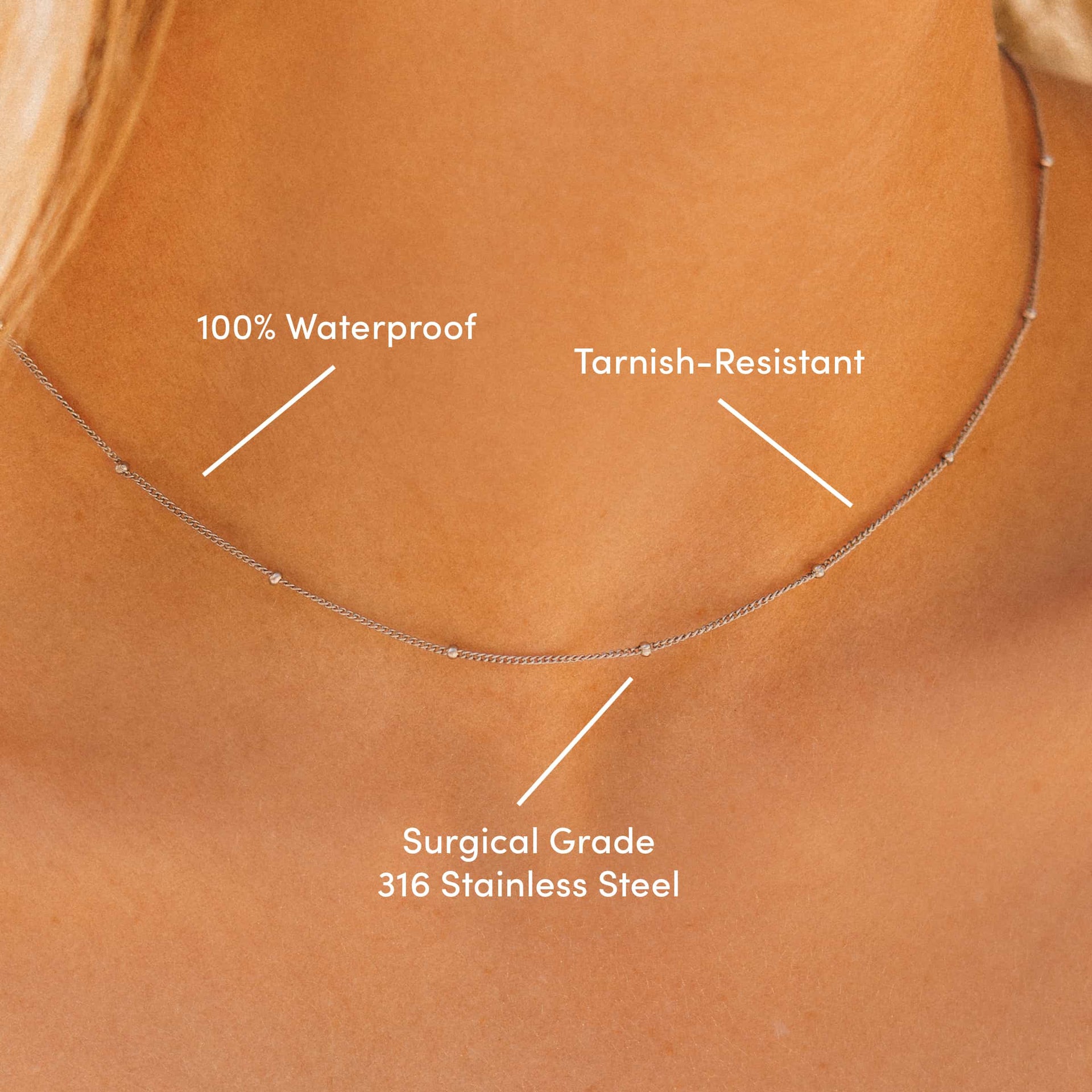 close up of dainty stainless steel satellite chain necklace labeled with "100% Waterproof, Tarnish-Resistant, & Surgical Grade 316 Stainless Steel" on a blonde model