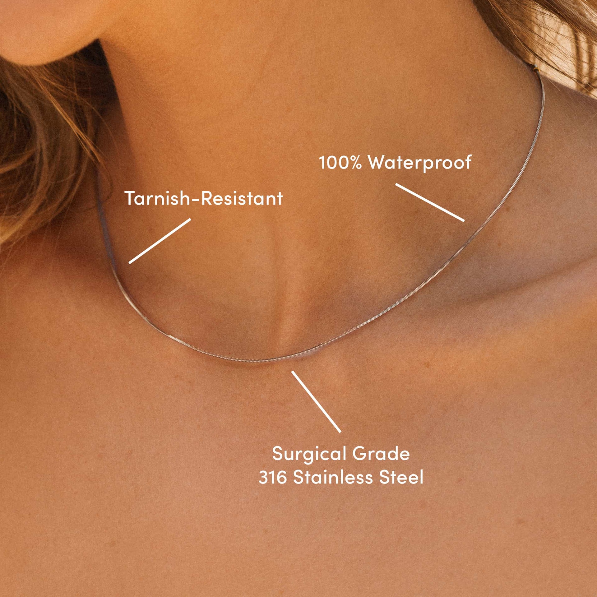 silver stainless steel snake chain on blonde model's neck with text that reads "tarnish-resistant, 100% waterproof, surgical grade 316 stainless steel" 