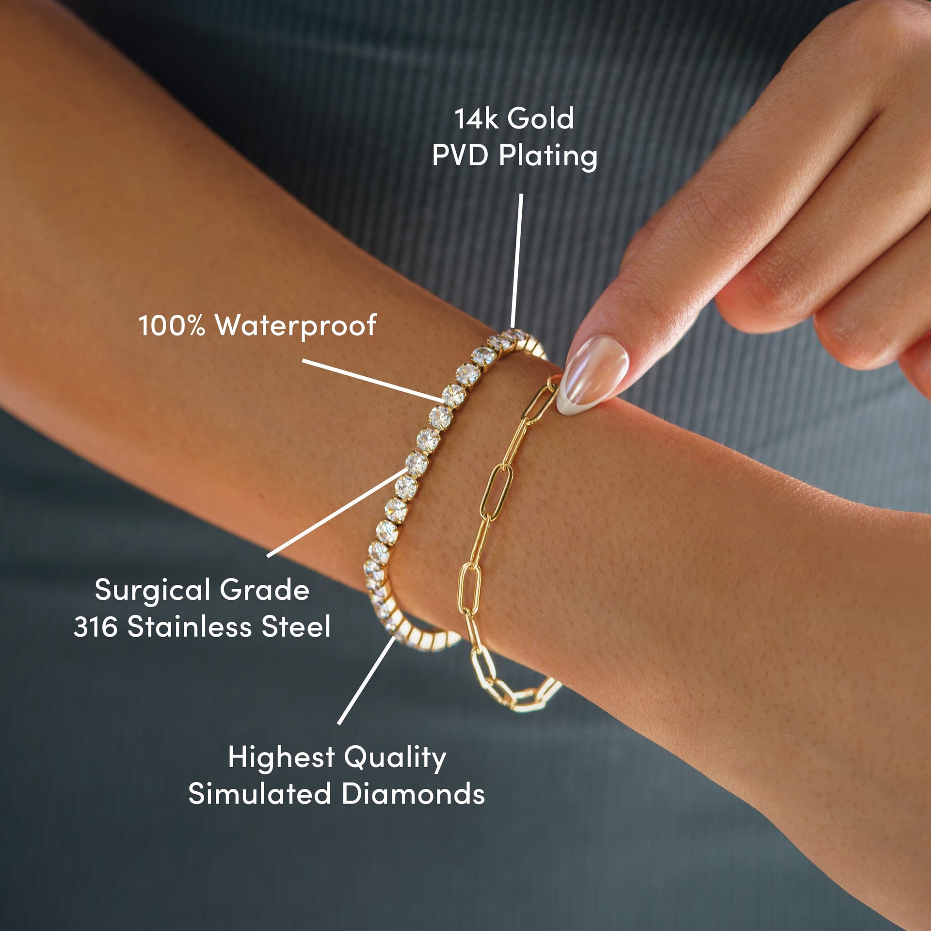 everyday gold tennis bracelet worn as a part of a bracelet stack with a gold paperclip necklace by model wearing dark colors with the text over it: Tarnish Resistant, Surgical Grade 316 Stainless Steel, Highest Quality Simulated Diamonds, 100% Waterproof