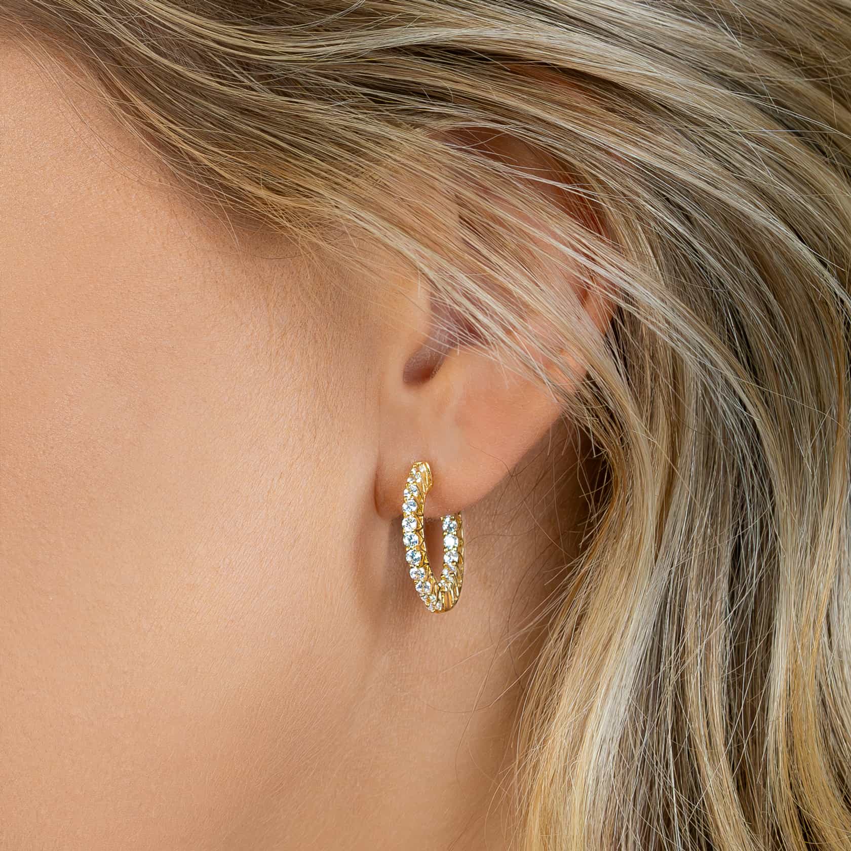 beautiful gold hoop earrings shown on blonde model's ear