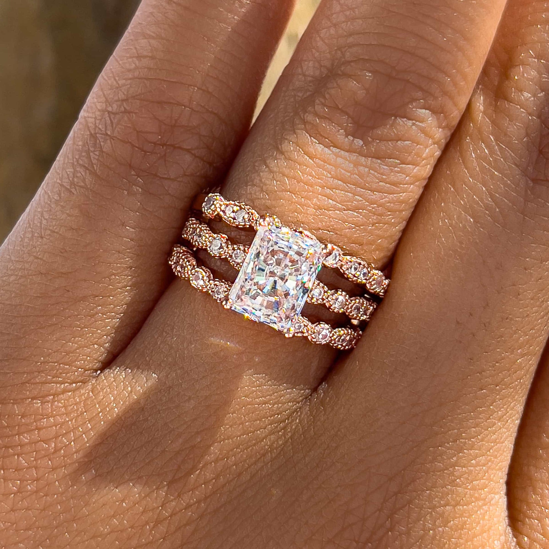 rose gold radiant cut vintage wedding ring set paired with a 2nd vintage style half eternity band to create a triple ring stack worn by female model