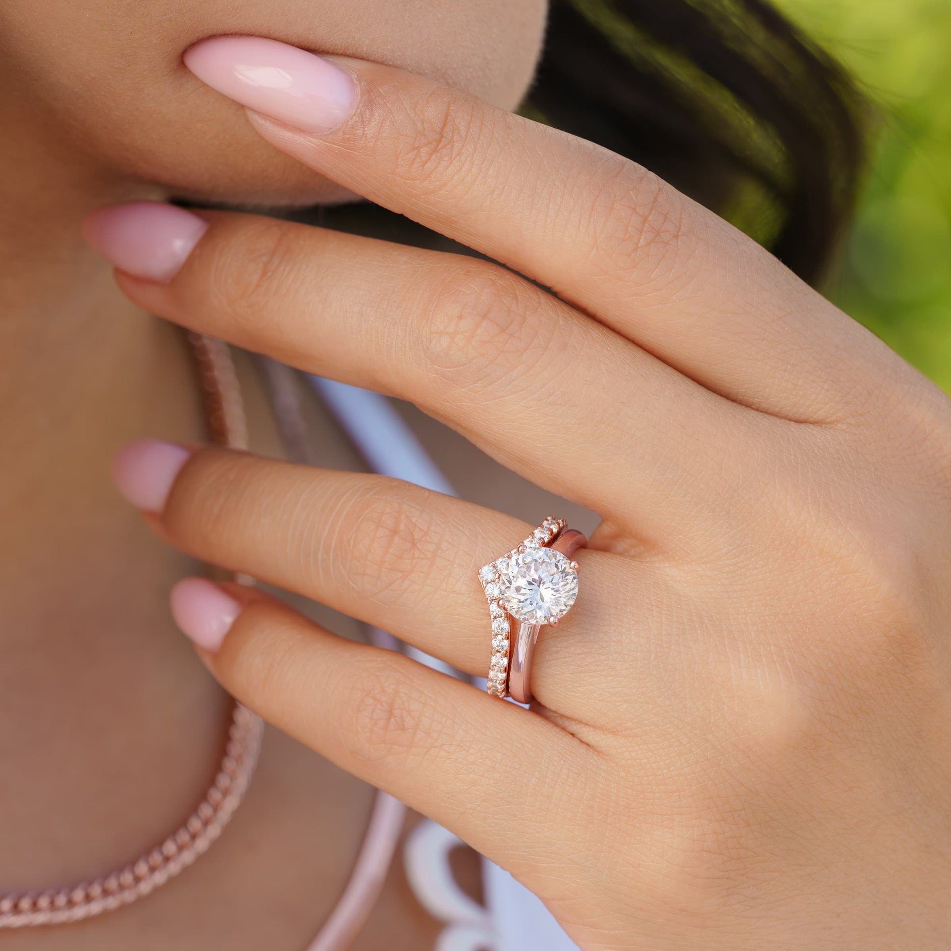 woman wearing rose gold wedding band with engagement ring