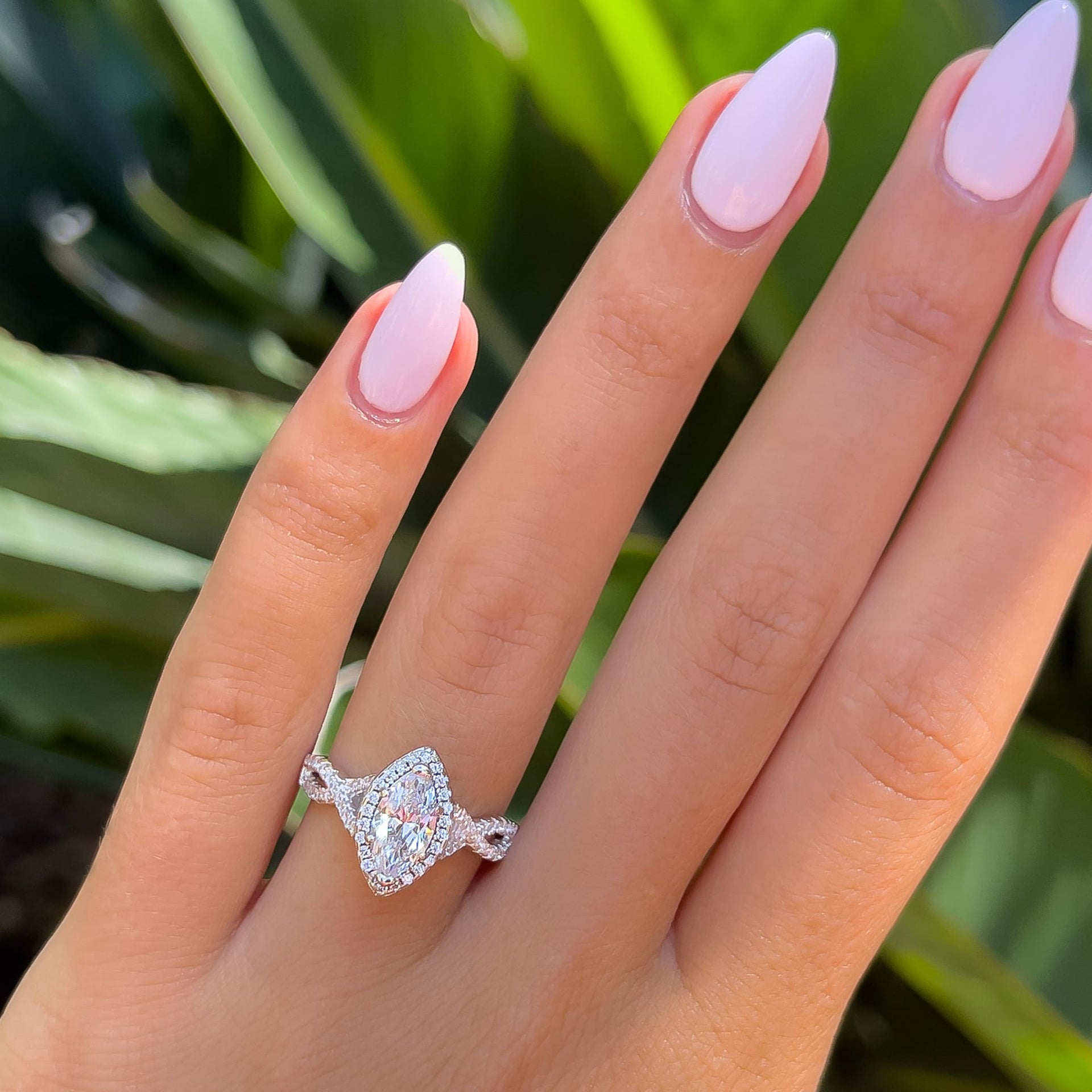 stunning halo marquise cut vintage style engagement ring on model with light pink nails