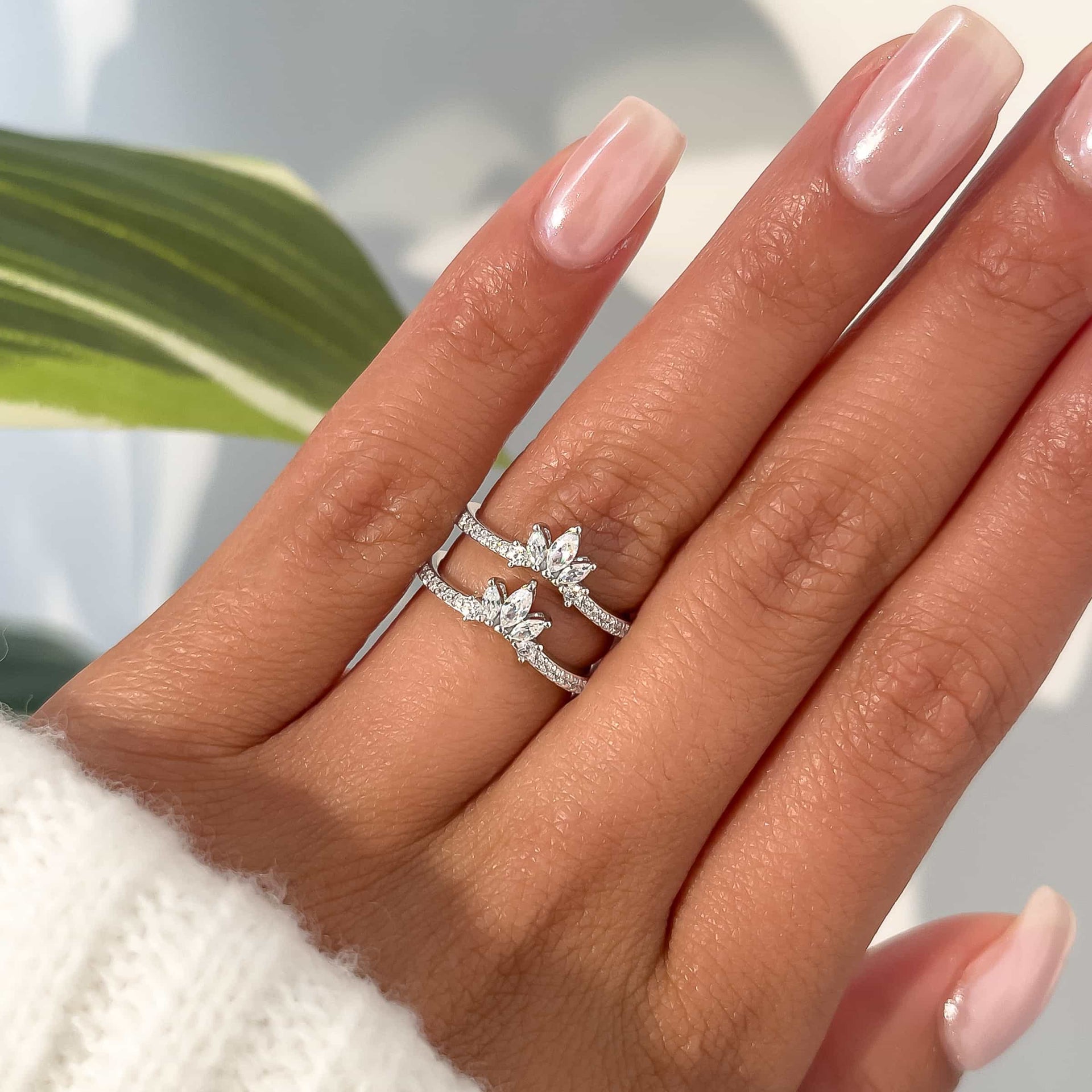 woman wearing two elsa bands in silver with white sweater and greenery in background