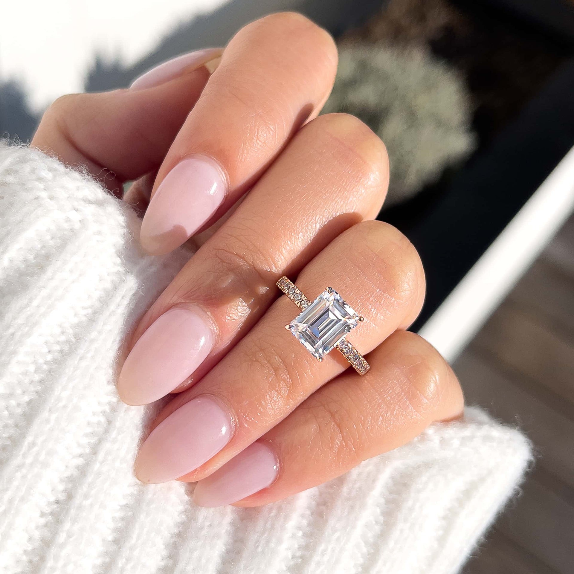 stunning emerald cut rose gold ring on model's finger