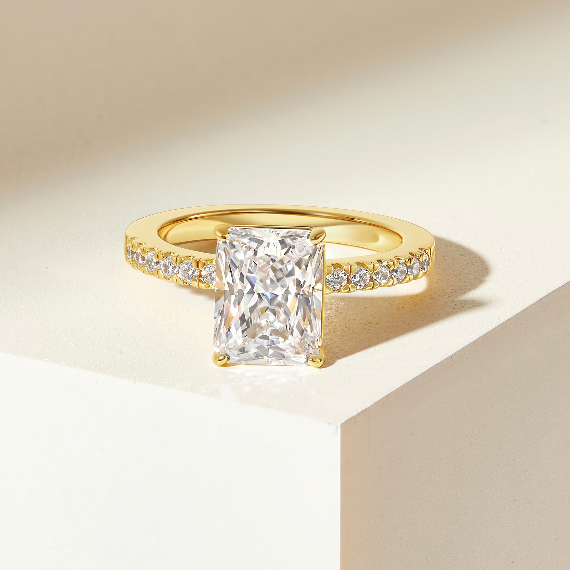 stunning gold radiant cut engagement ring with half eternity band on cream colored background