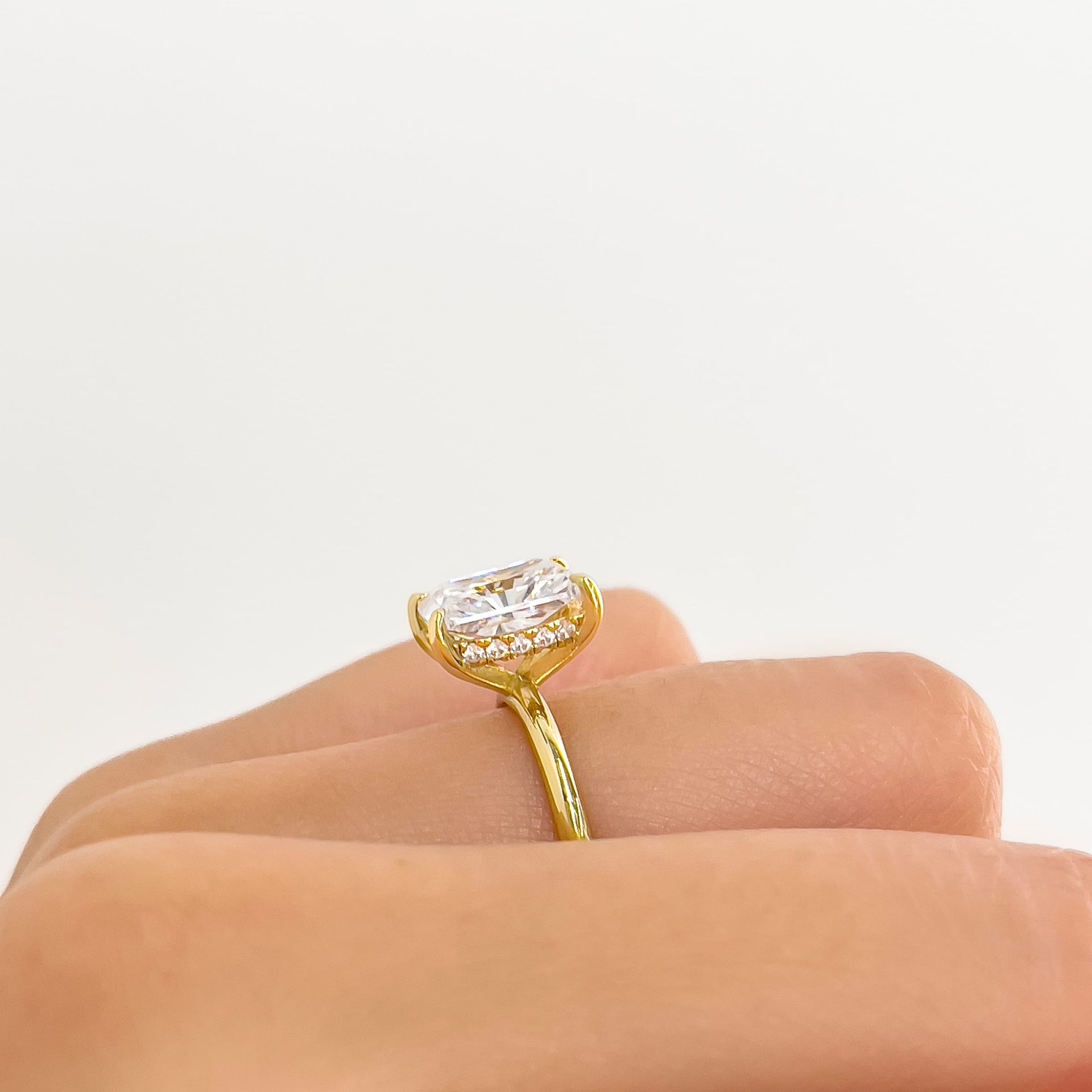 setting shot of gold 3 carat radiant cut solitaire engagement ring with hidden halo detailing