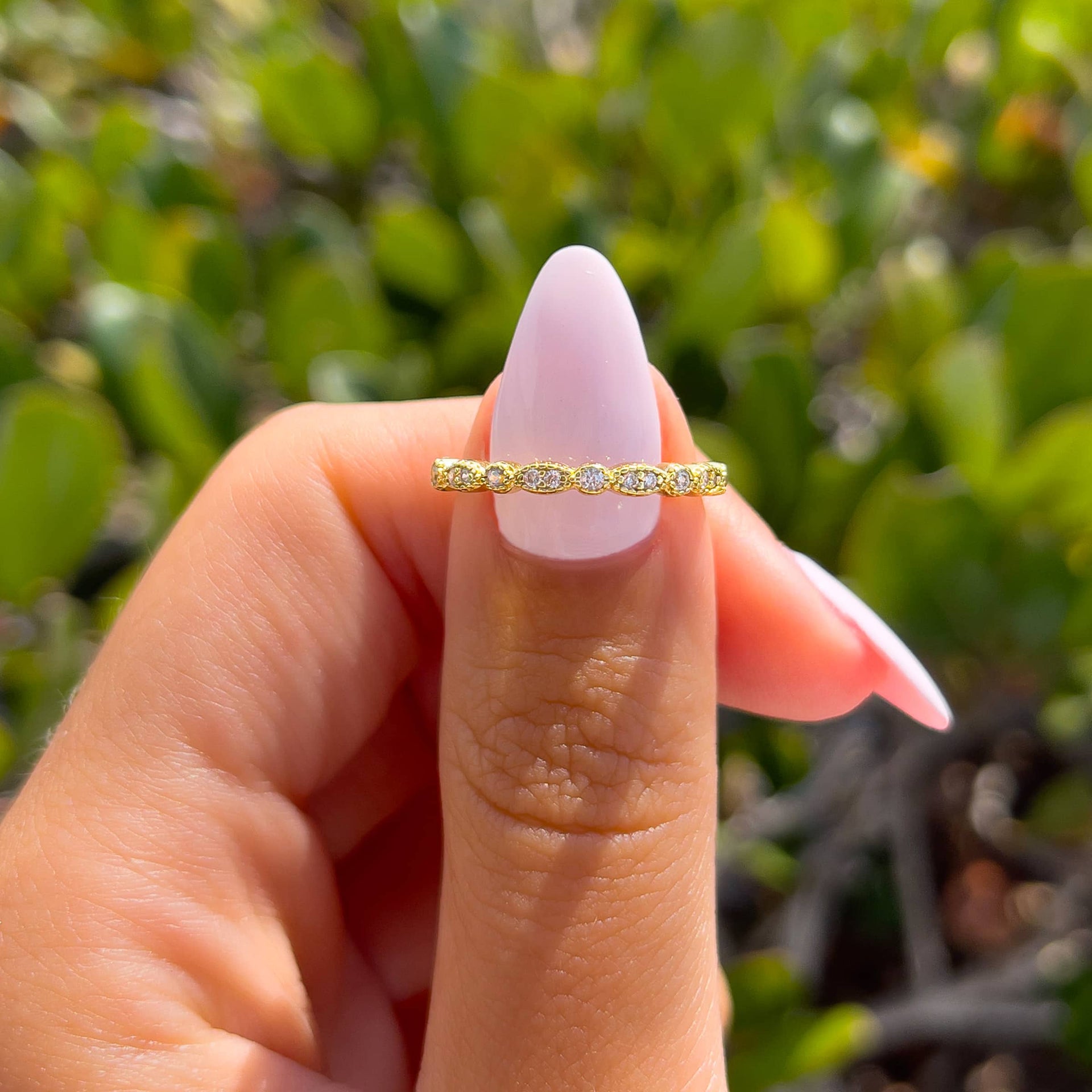 gold vintage half eternity band on model with light pink nails