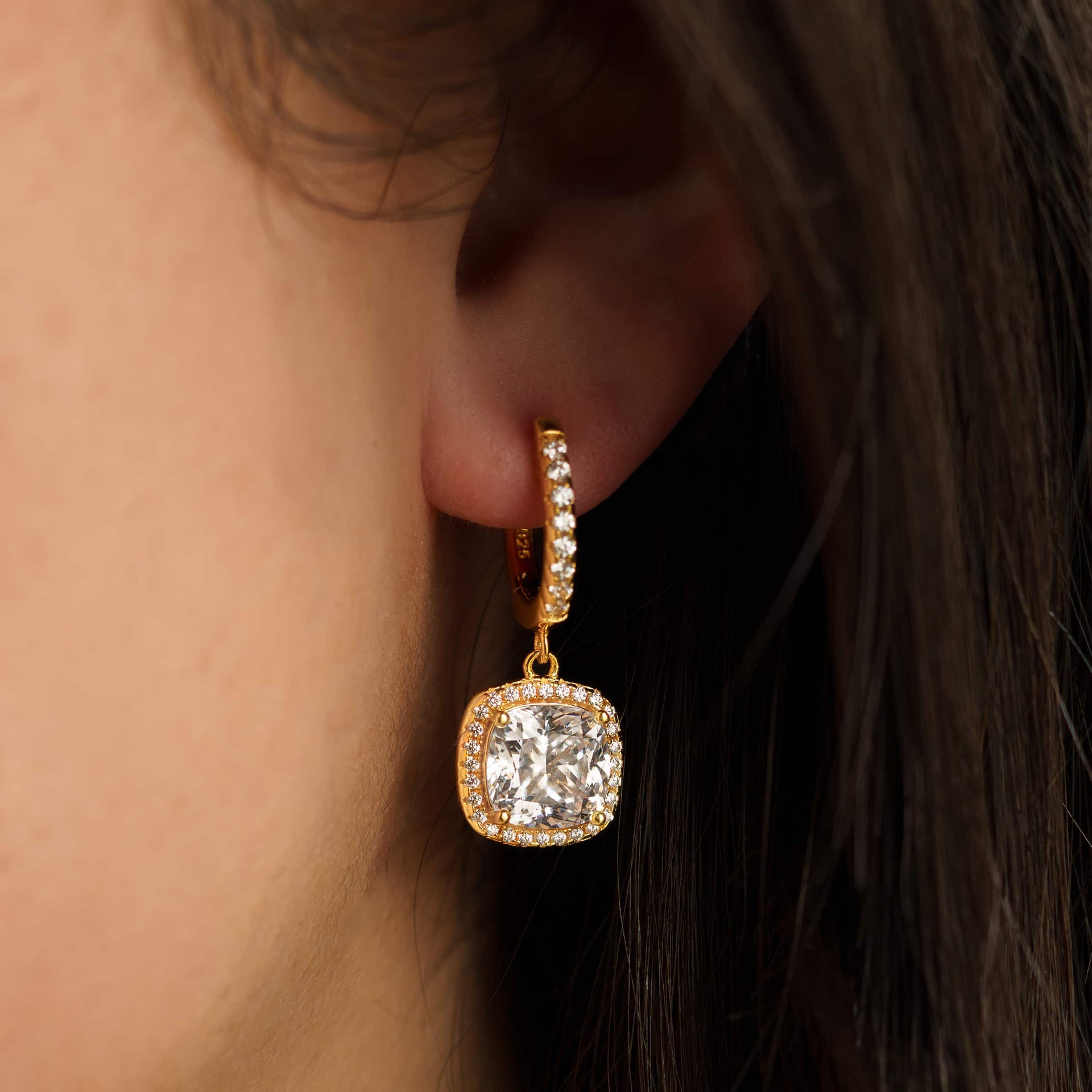 bold, gold cushion cut halo pendant dangling hoop earrings on model