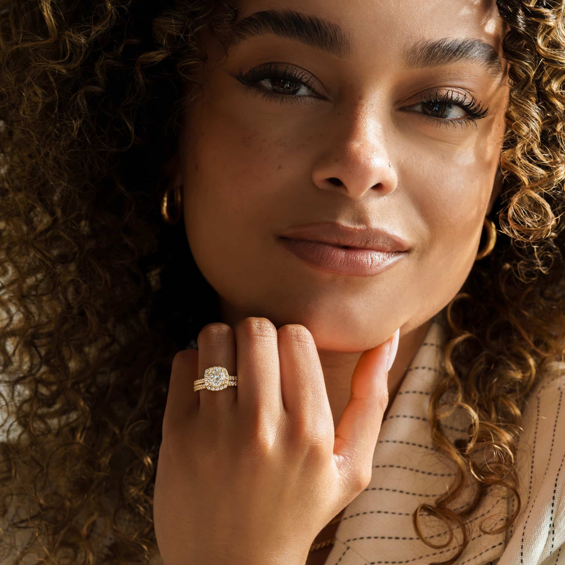 gorgeous gold halo cushion cut wedding ring set on models hand