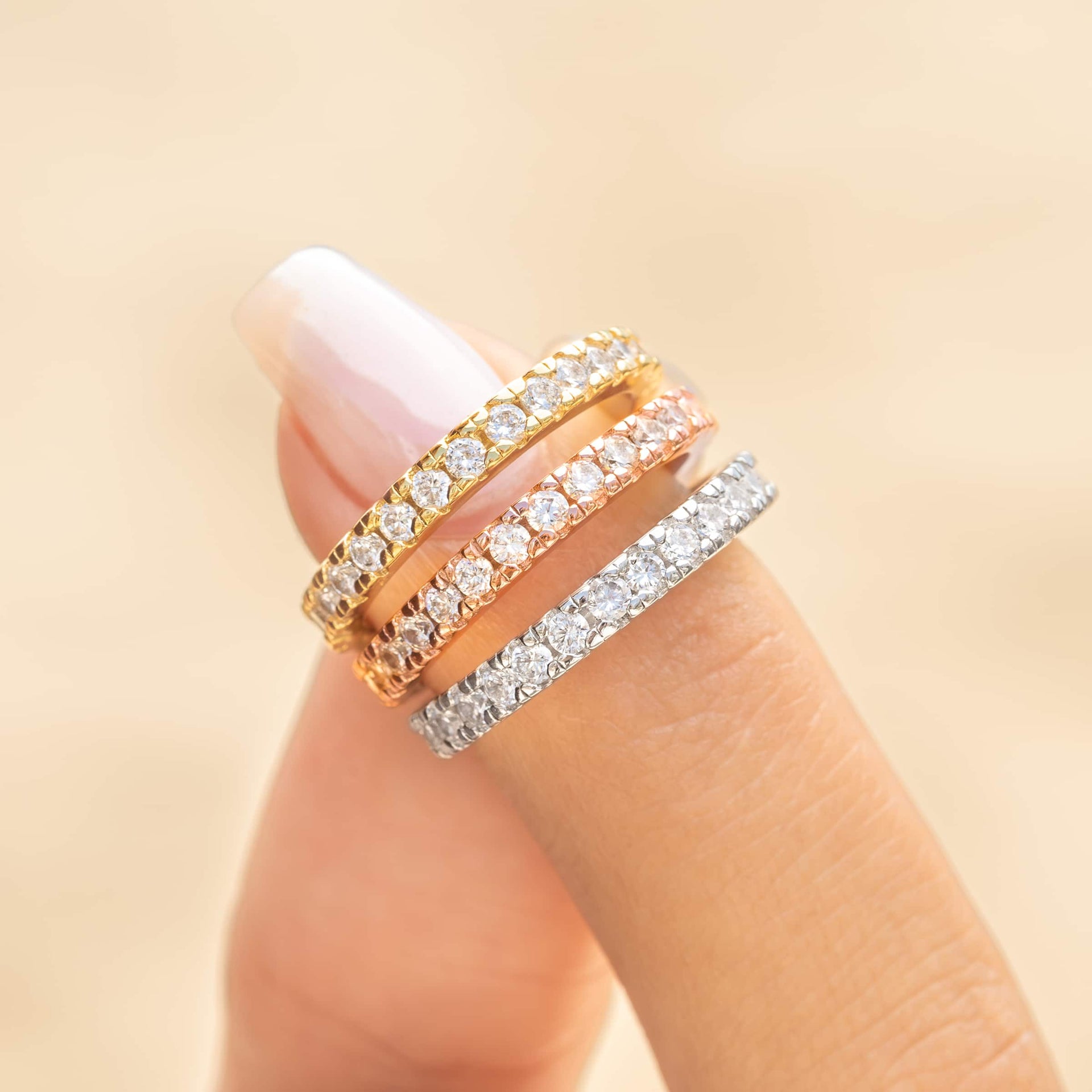woman pinching all three colors eternity wedding band