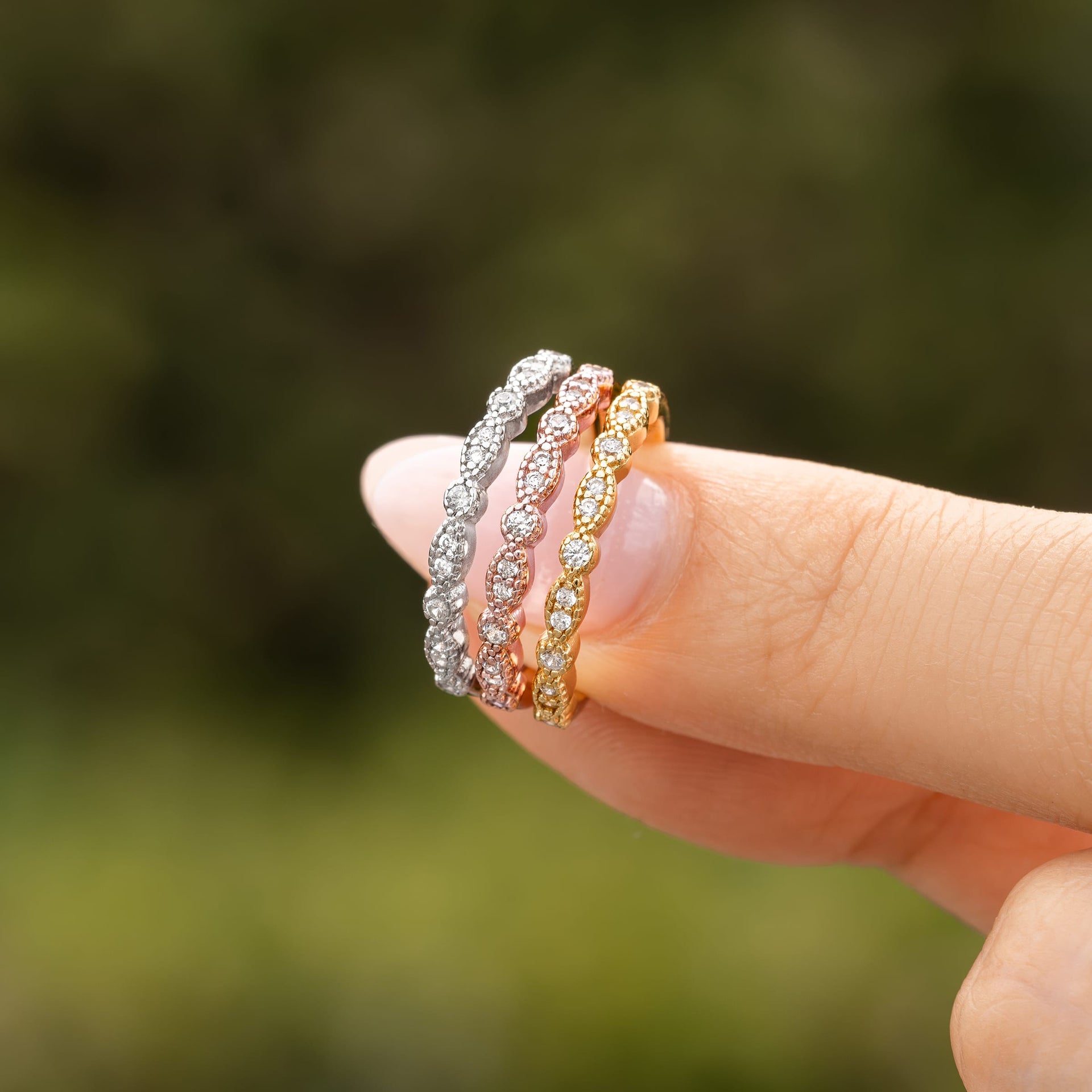 woman pinching three colors of vintage wedding band