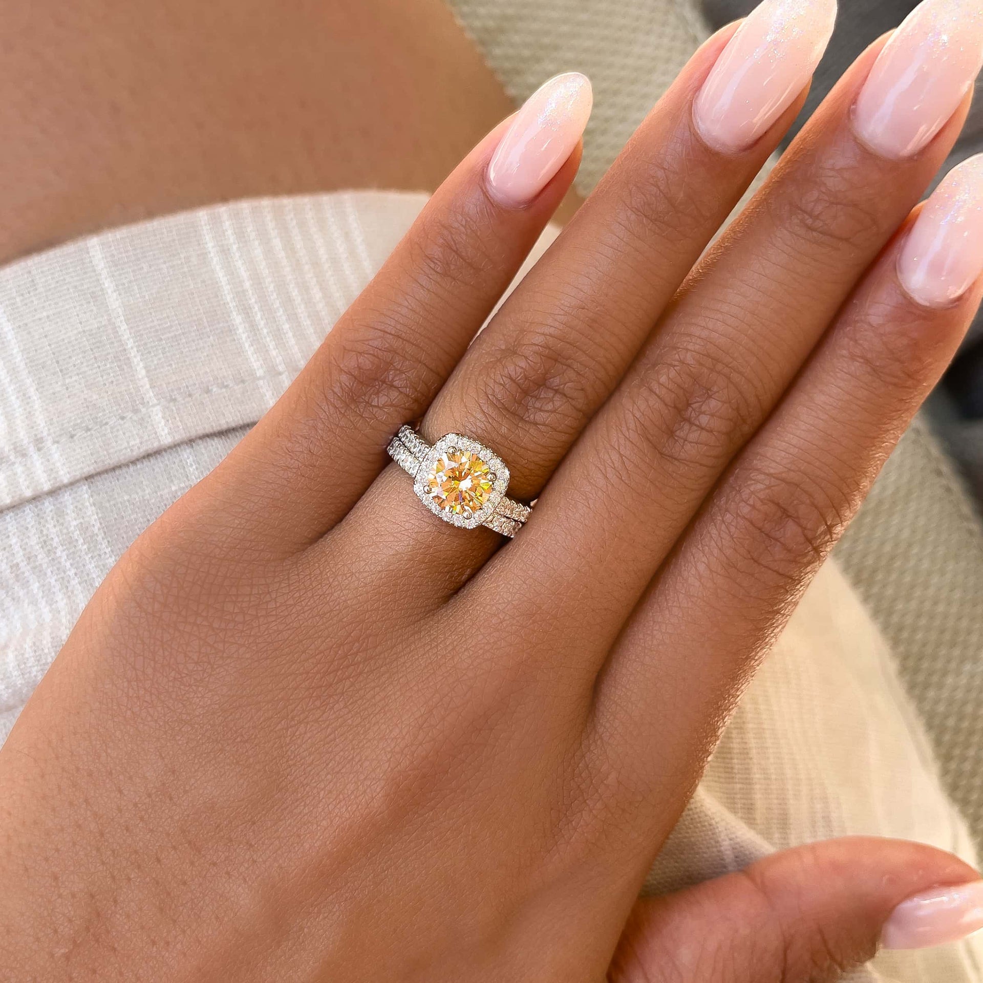 stunning halo morganite engagement ring with matching band on model with neutral nails