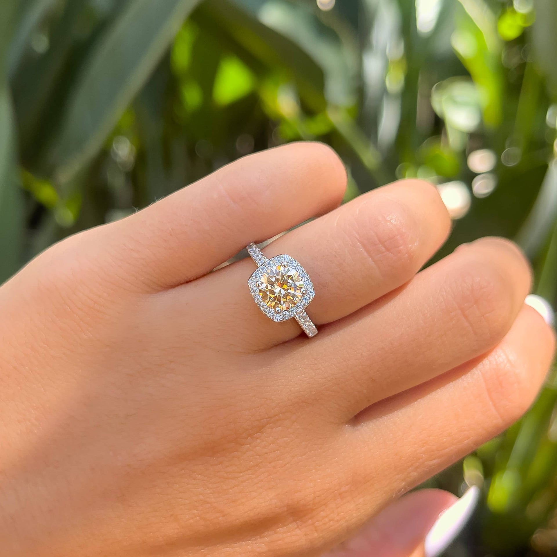 1.5 carat round cut simulated morganite engagement ring on female model in front of greenery