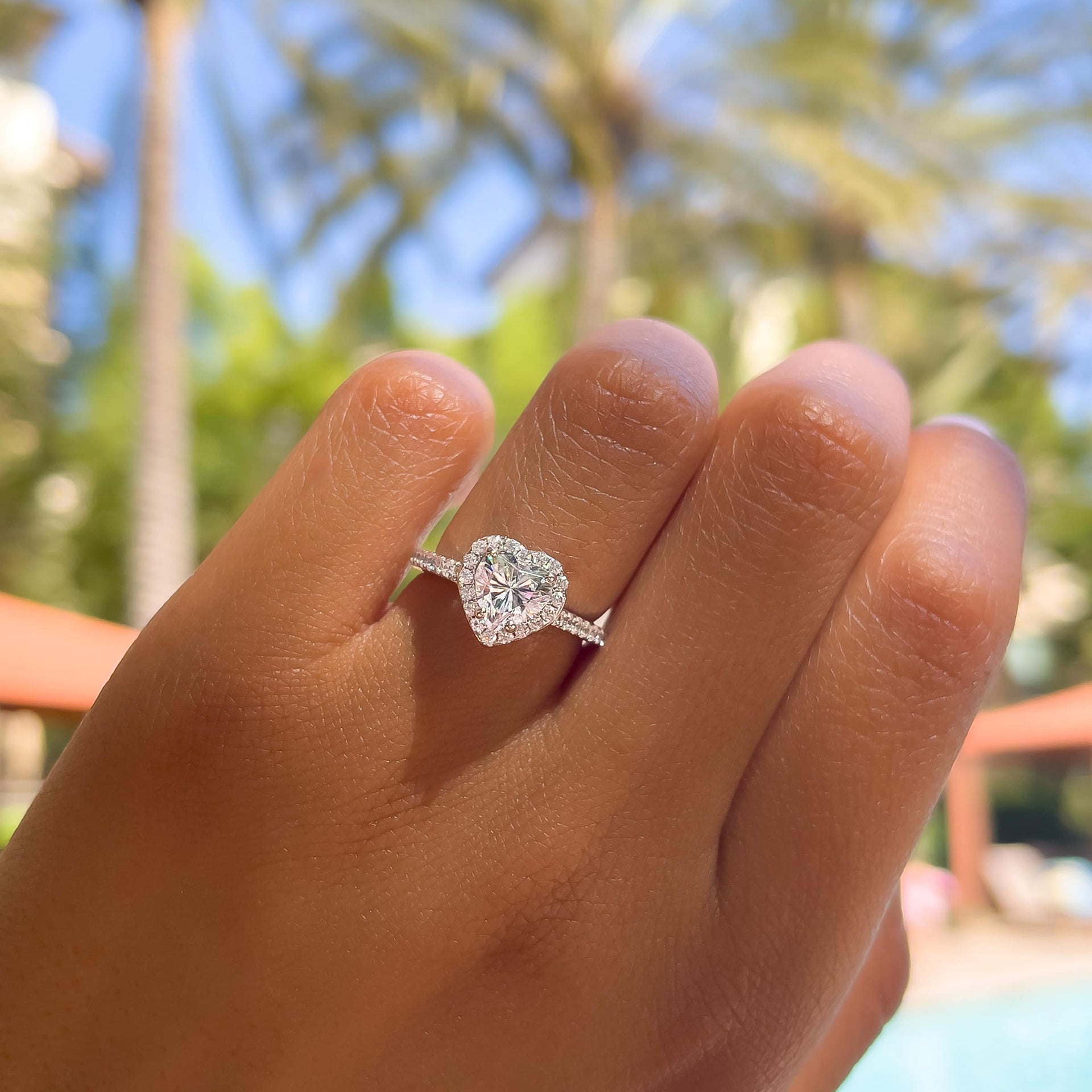 unique heart shape engagement ring on model who is poolside