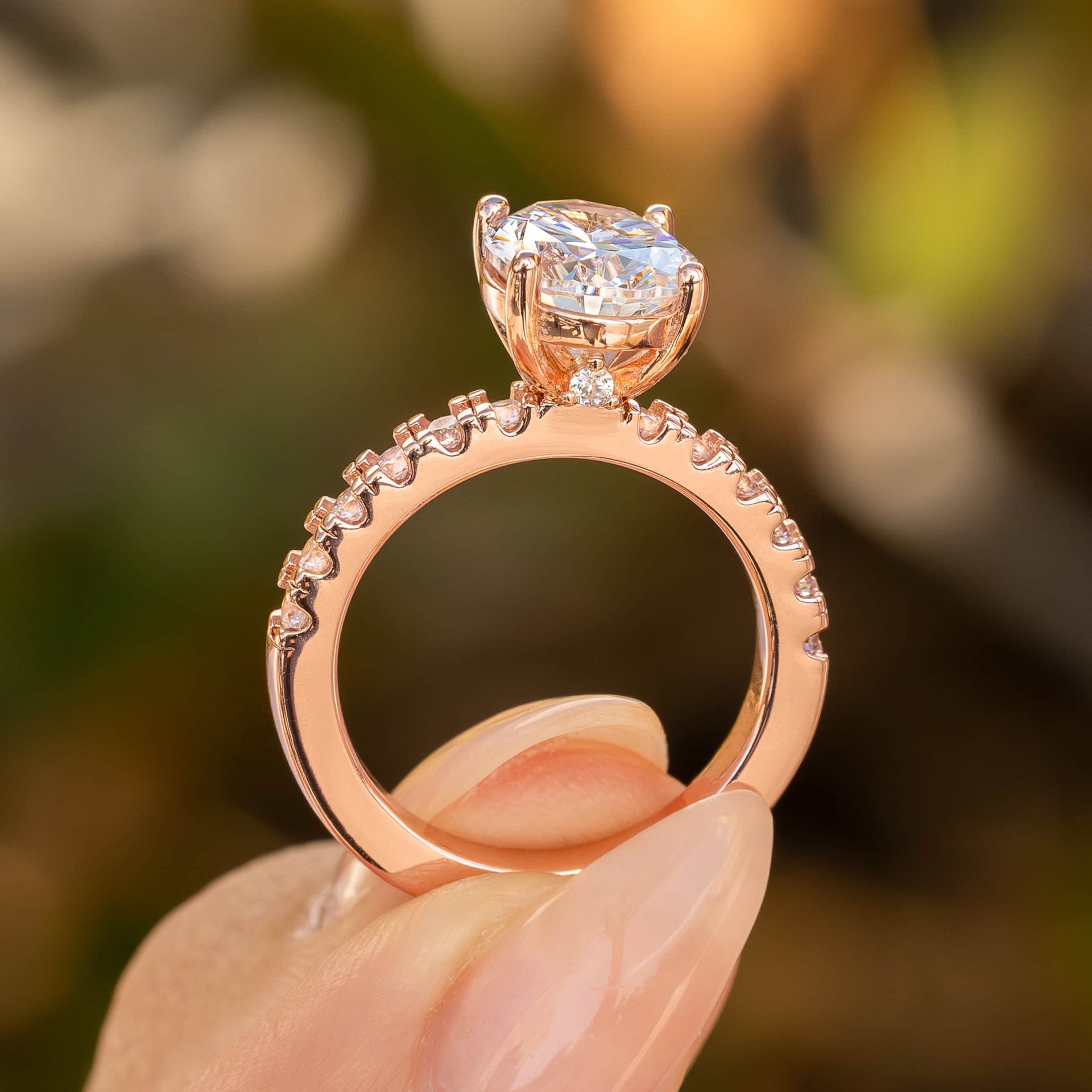 Sleek side view of rose gold engagement ring with a half eternity band