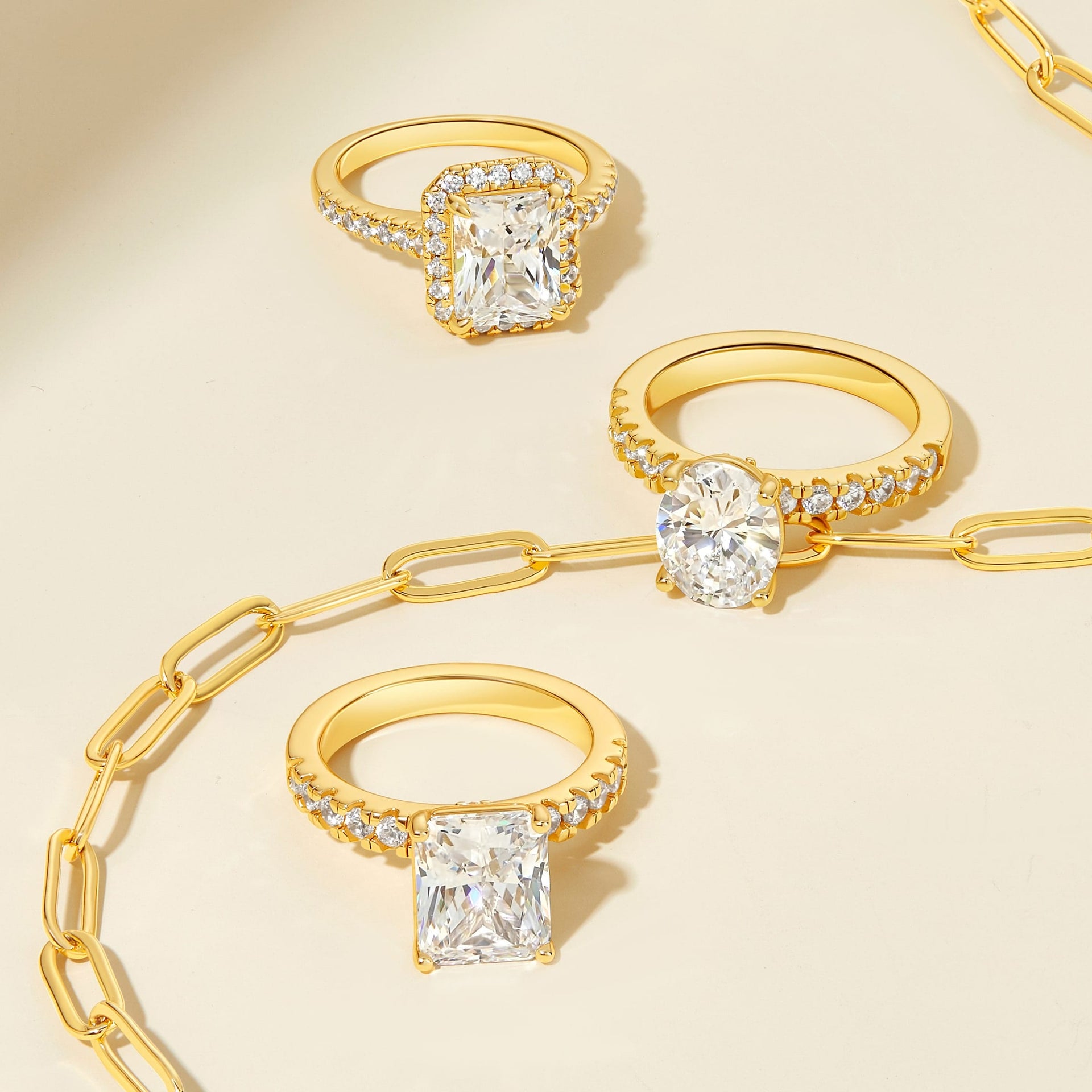 three stunning and affordable engagement rings shown with a minimal gold necklace laid across