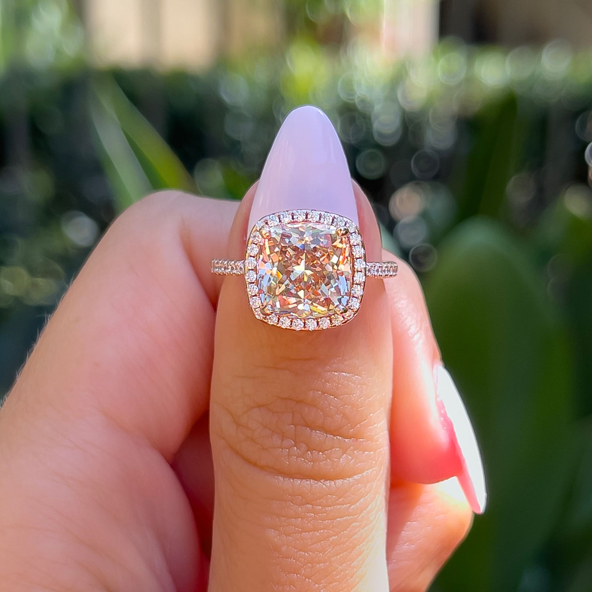 stunning 3 carat rose gold simulated morganite halo engagement ring on model with light pink nails