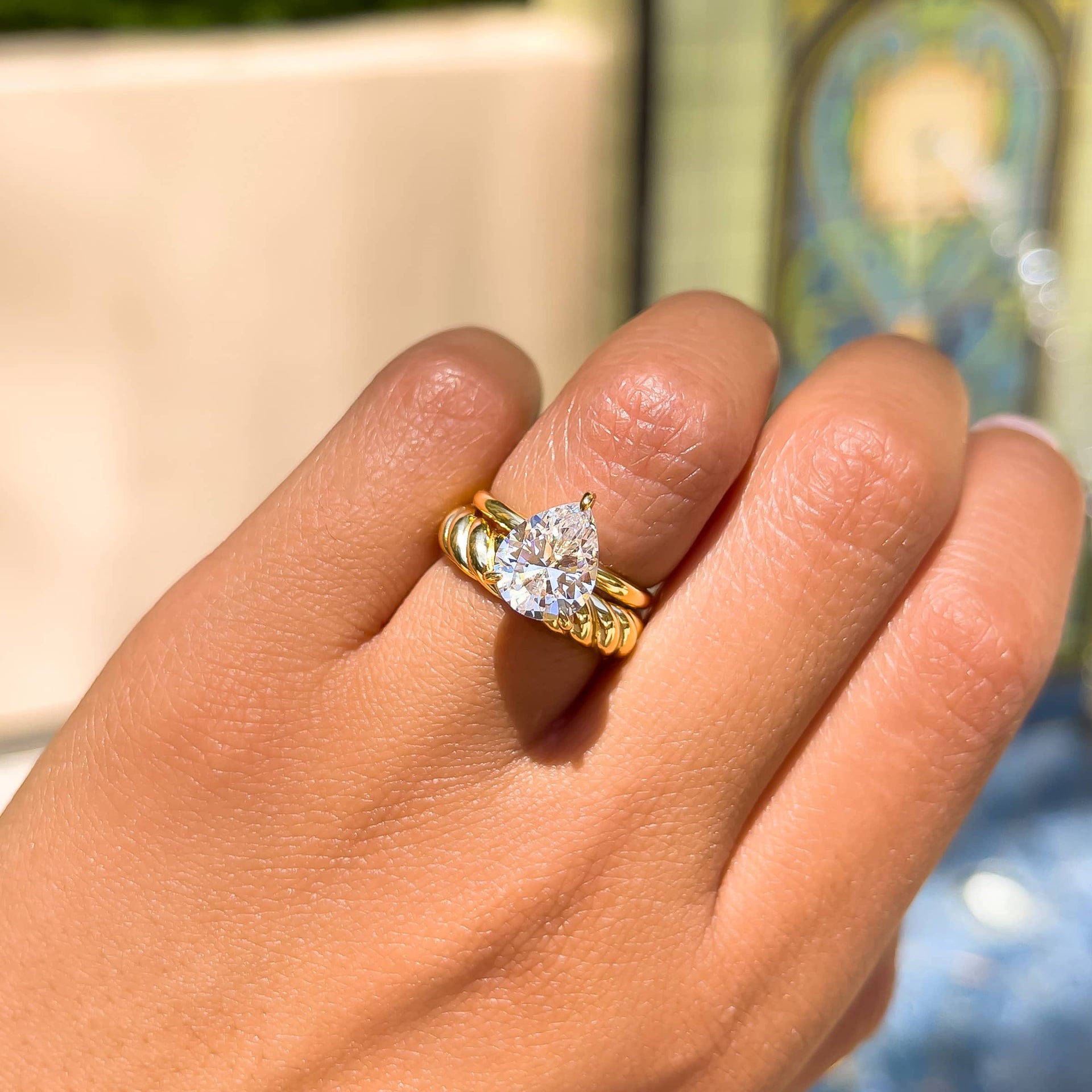 stunning 3 carat pear cut solitaire engagement ring paired with bold gold wedding band