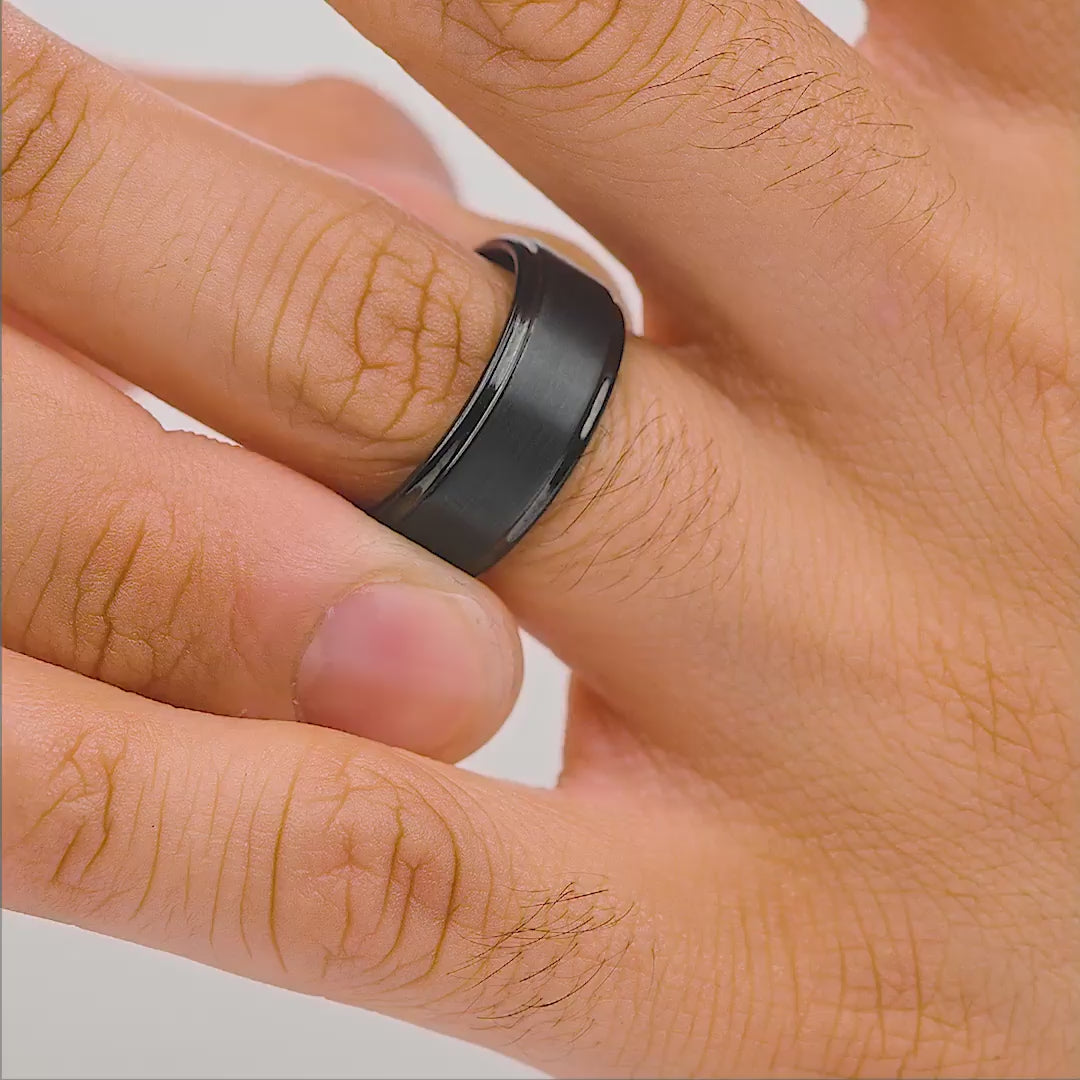 black tungsten men's wedding band shown in wiggle