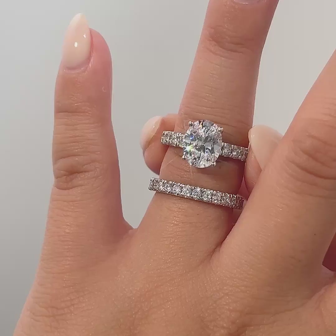 video of silver oval cut wedding ring set on model with neutral nails