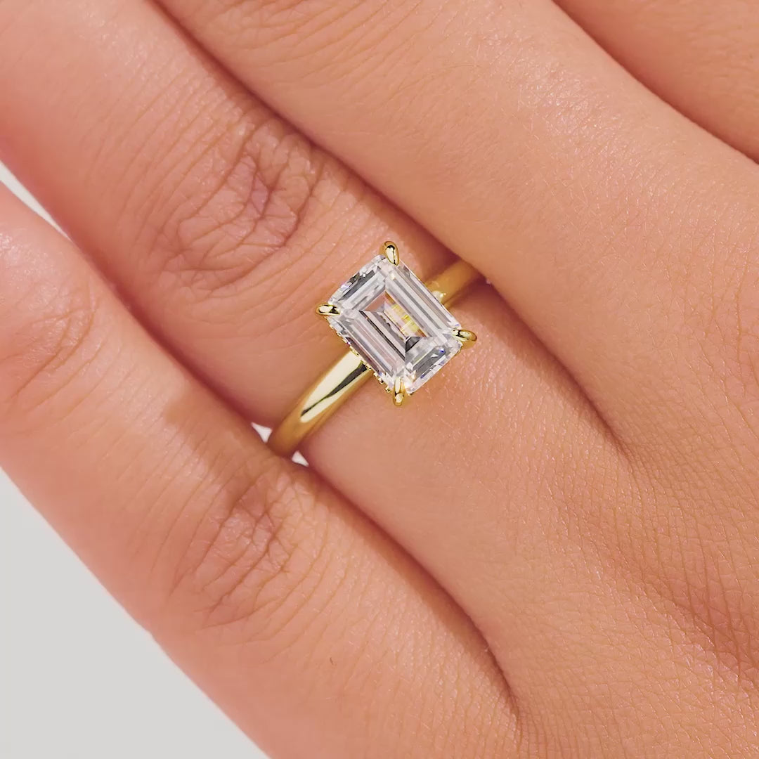 video of gold 1.5 carat emerald cut solitaire engagement ring on model